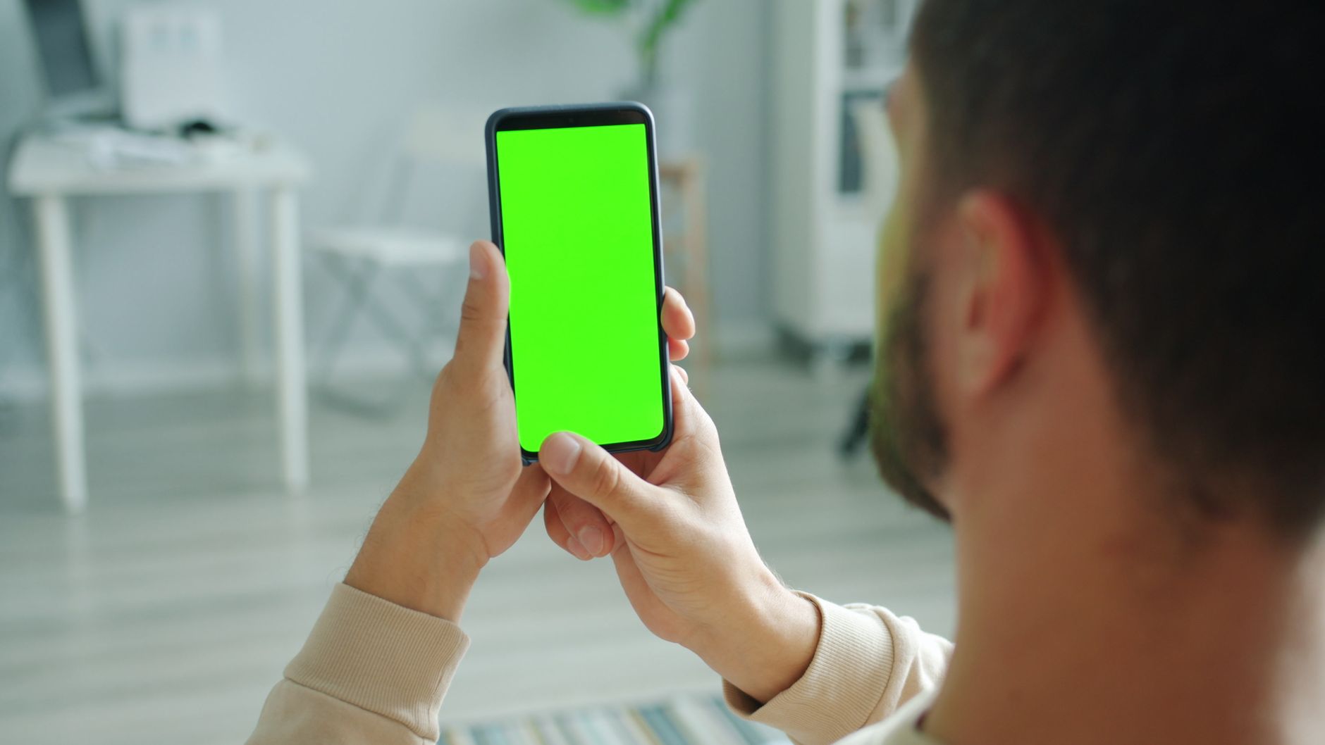 person holding smartphone checking signal bars at home