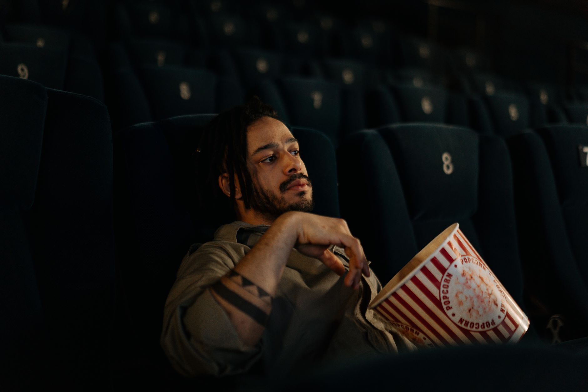 person watching thriller movie alone dark room