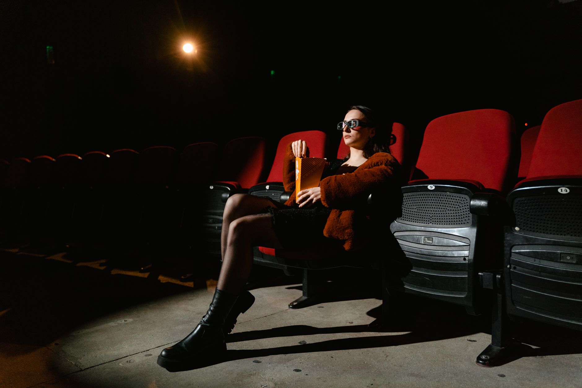 person watching thriller movie alone dark room