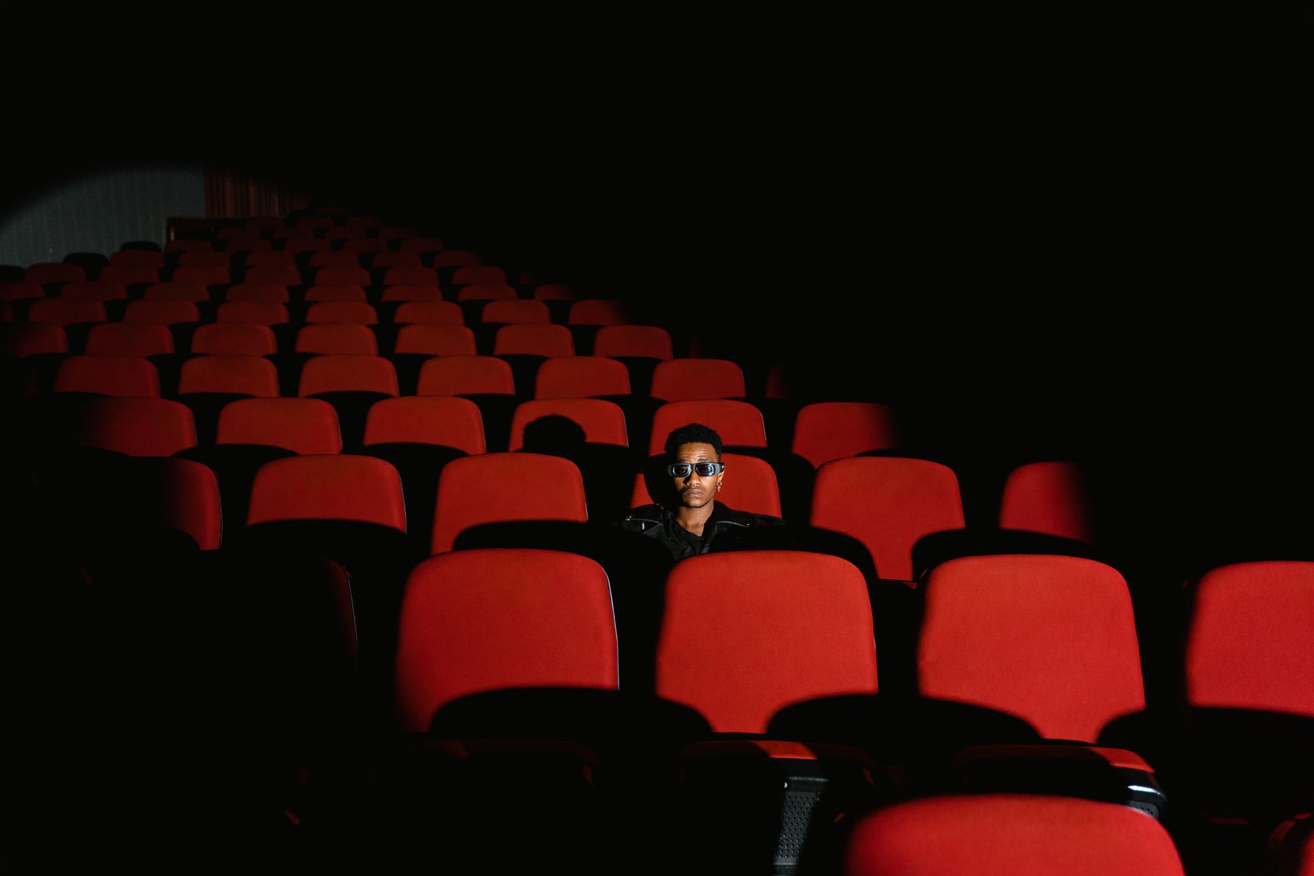 person watching thriller movie alone dark room