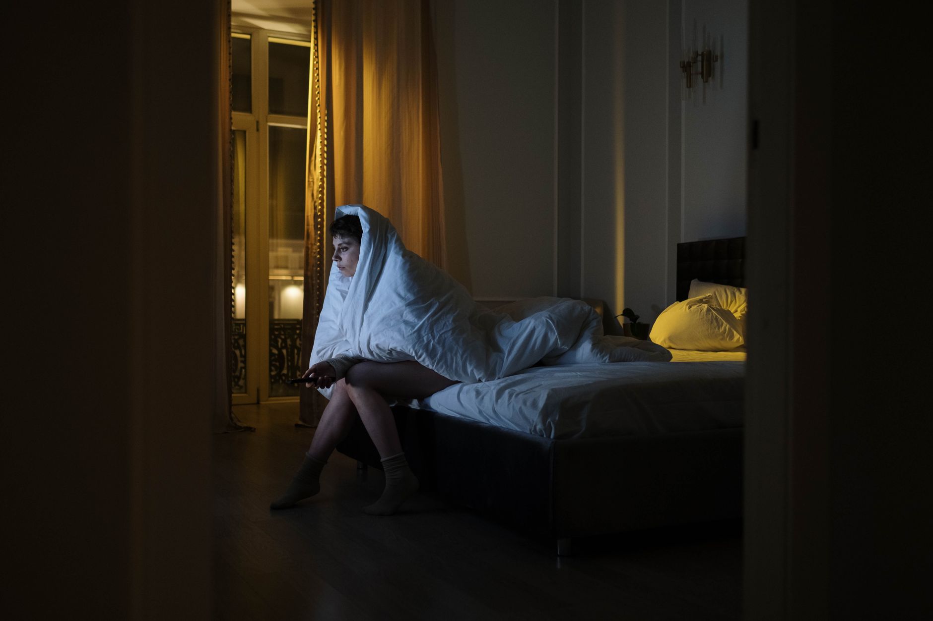 person watching thriller movie alone dark room