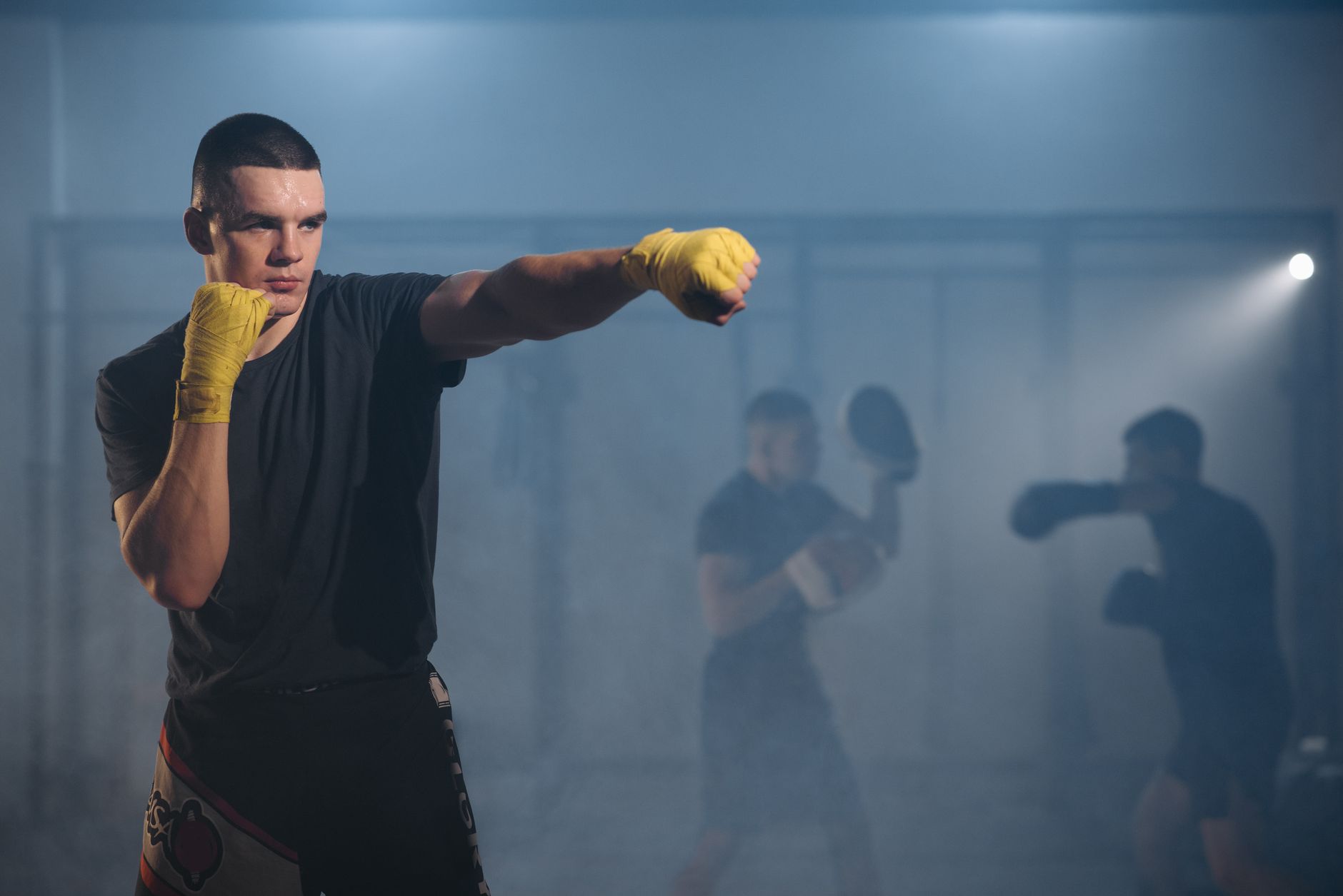MMA fighter training punching bag in gym