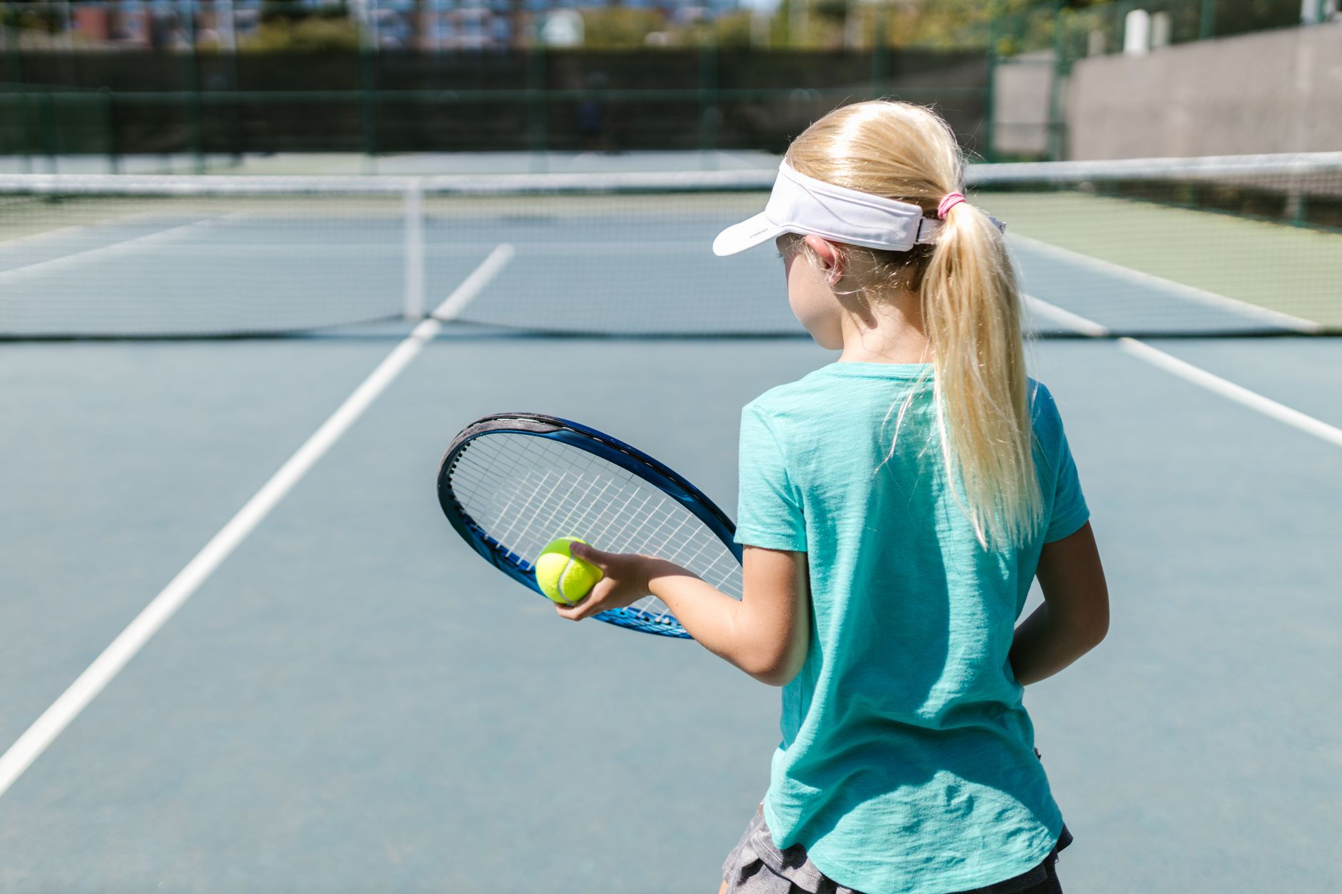female tennis player serving on court sunny day