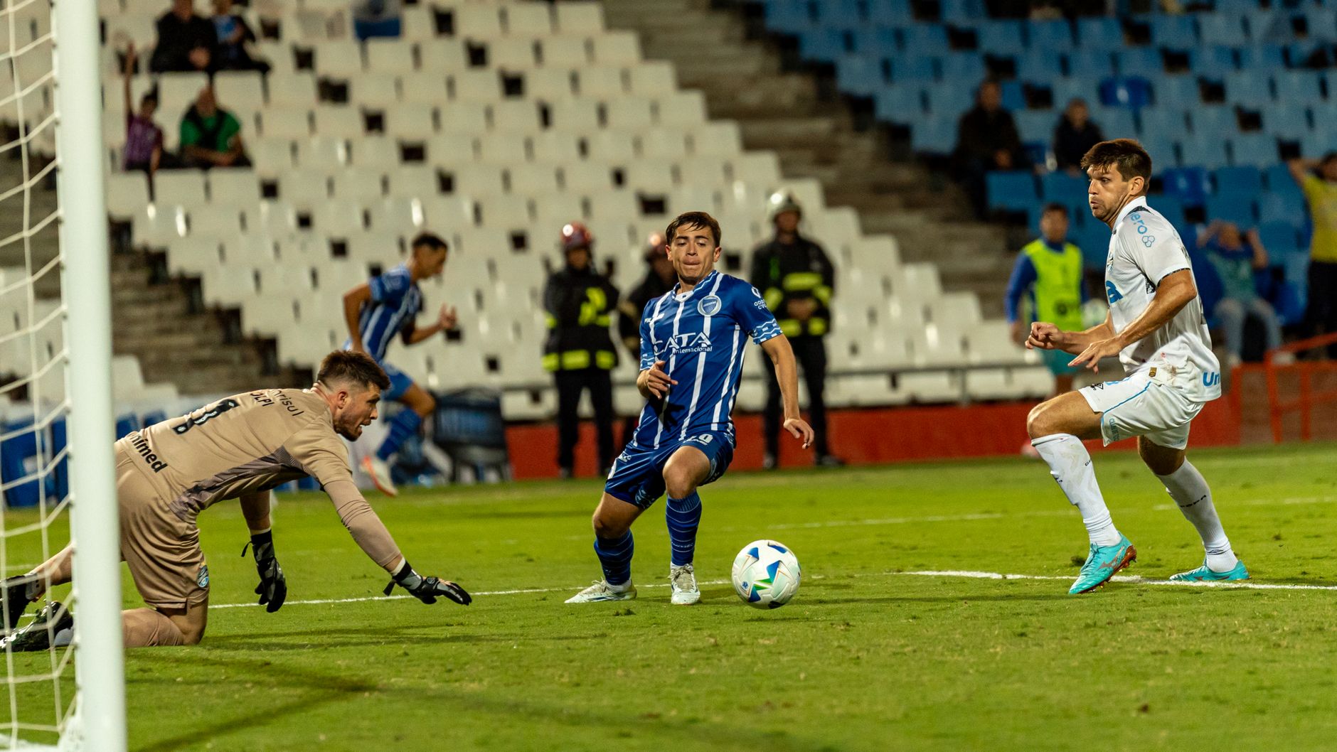 football players competing for ball on field in stadium