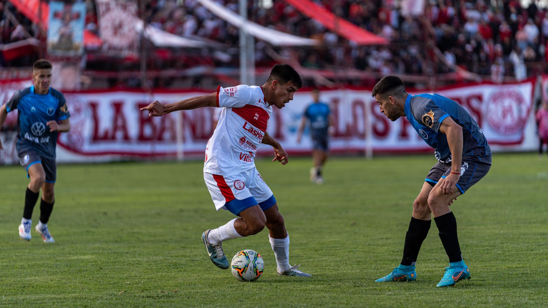 midfielder dribbling ball past opponent during evening match