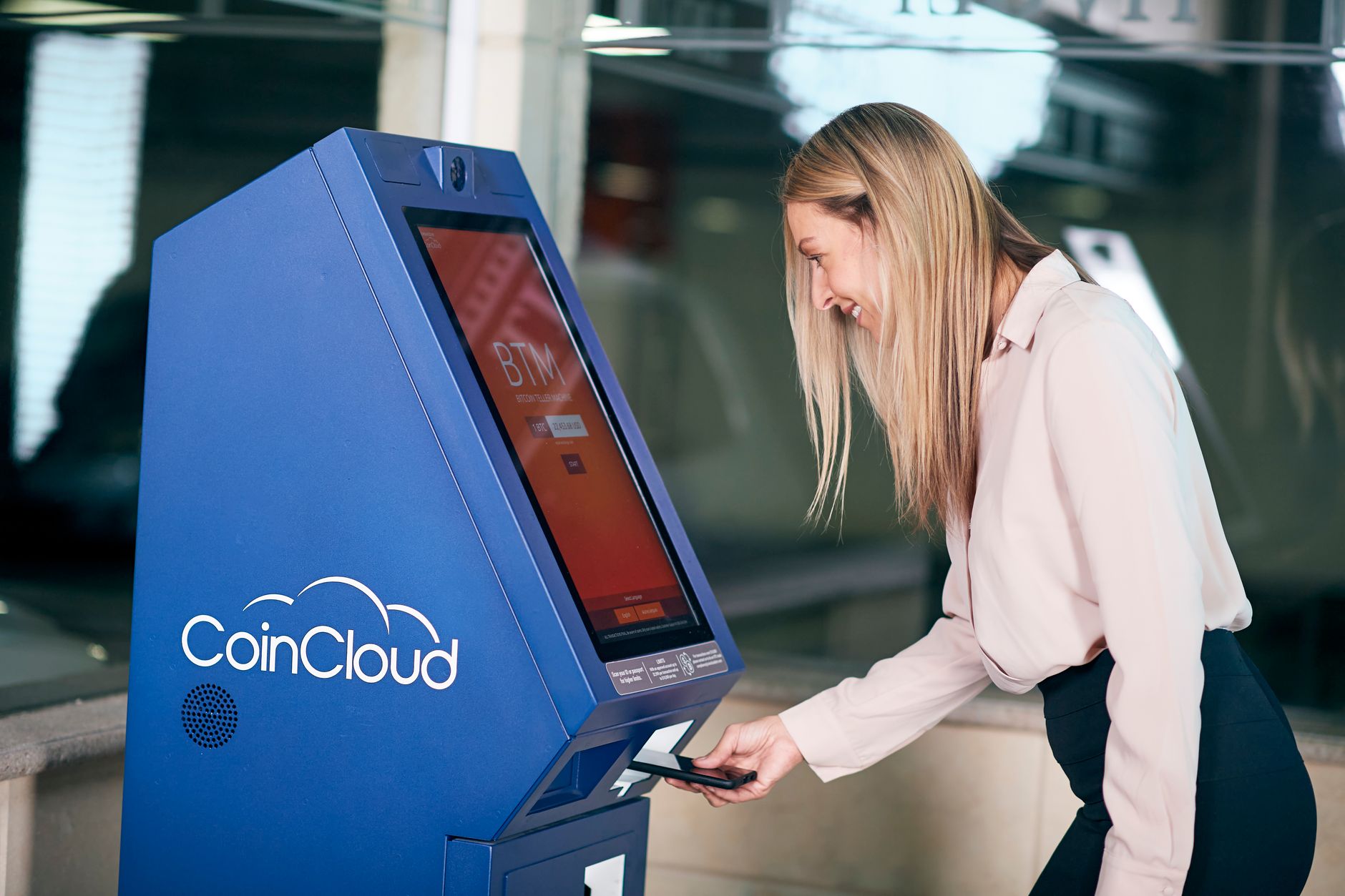 person standing next to Bitcoin ATM machine