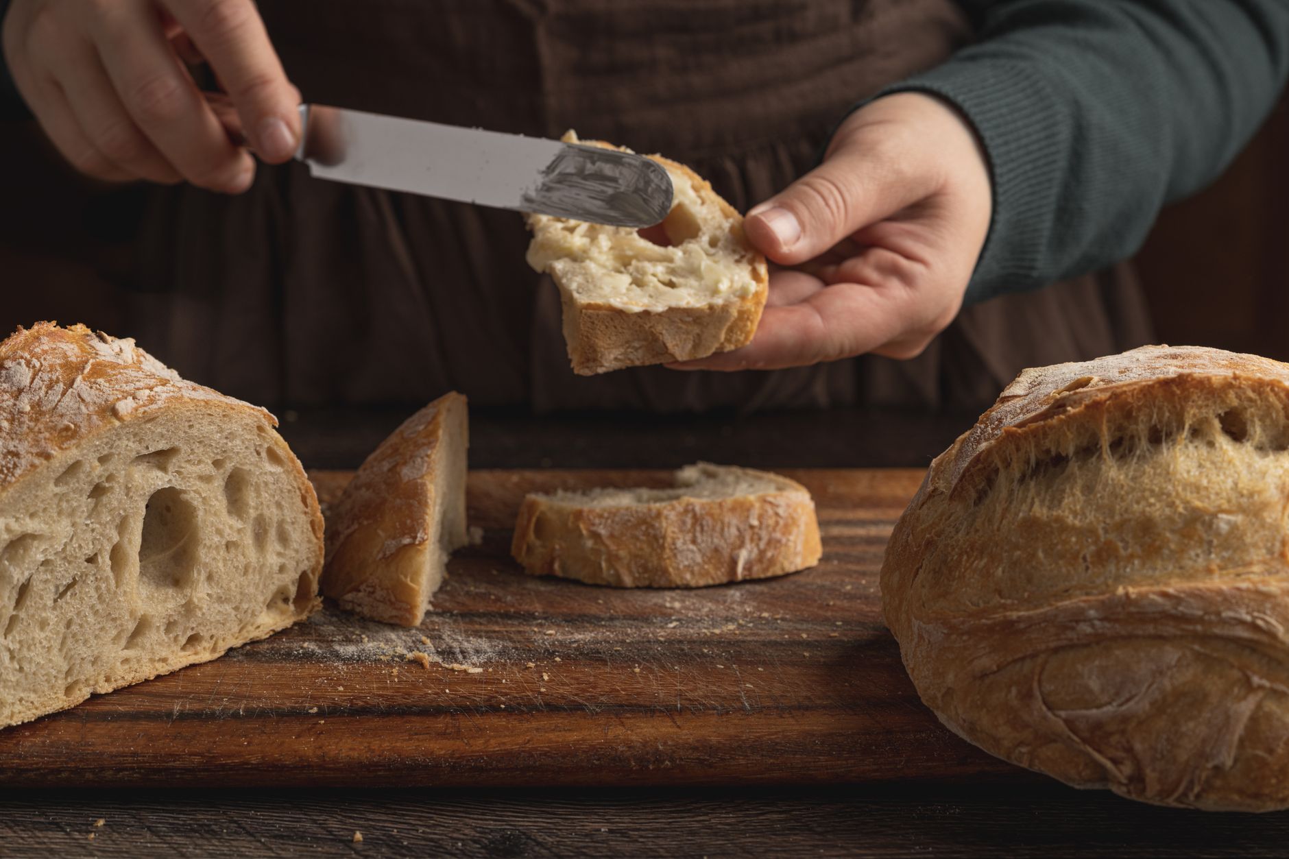 woman slicing artisan bread for healthy breakfast