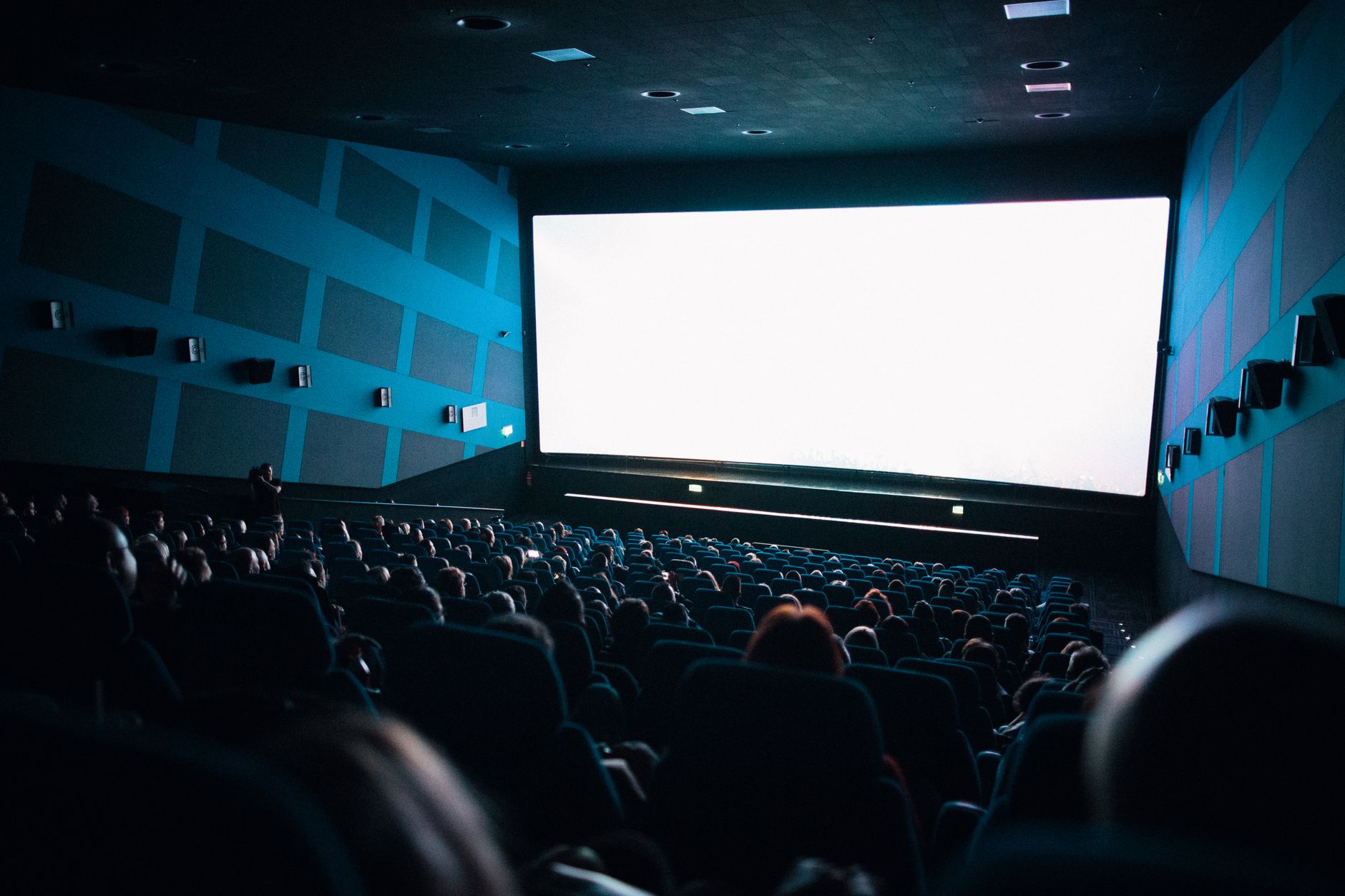 audience watching movie in dark cinema hall