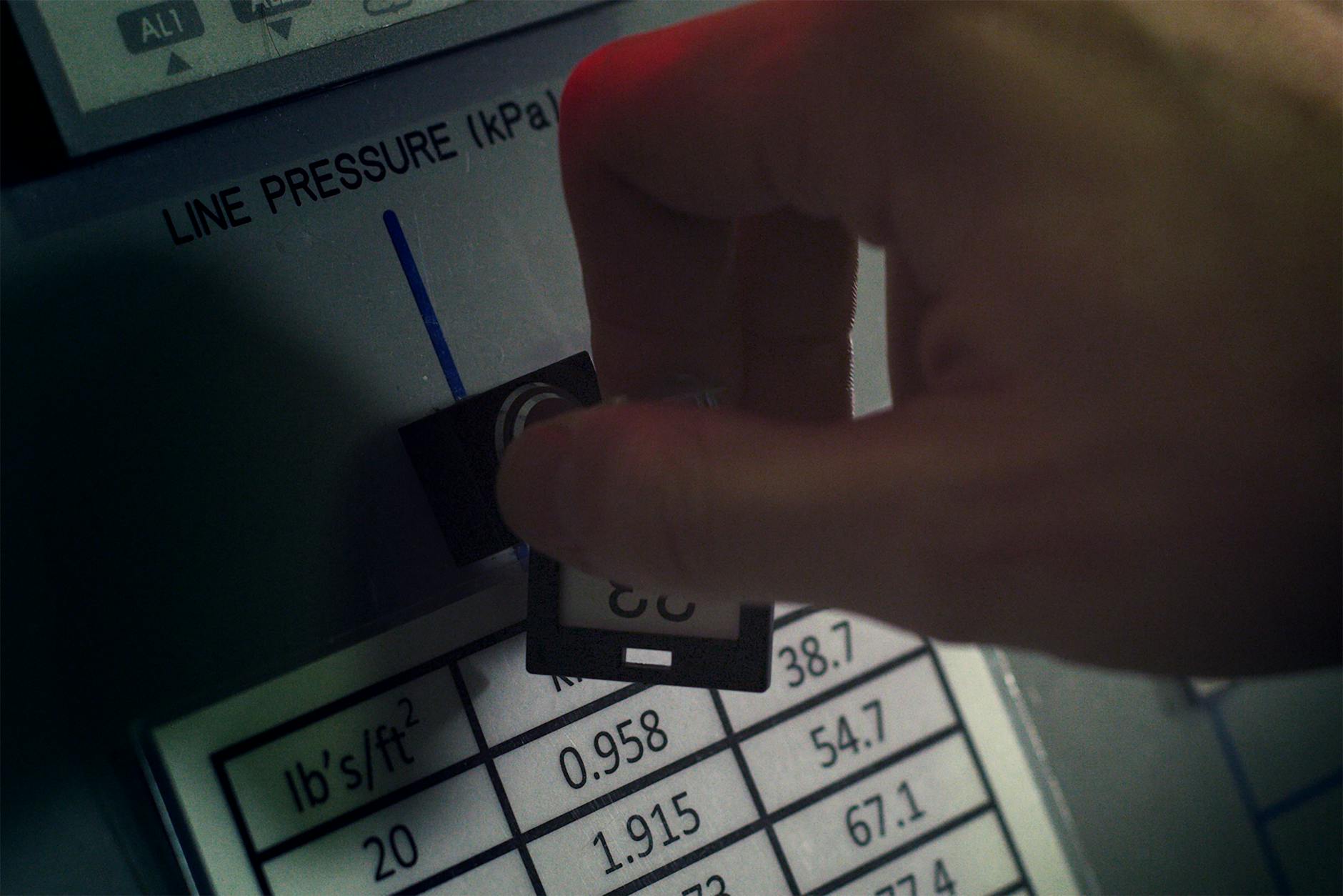 close-up of digital electricity meter display with hand entering numbers