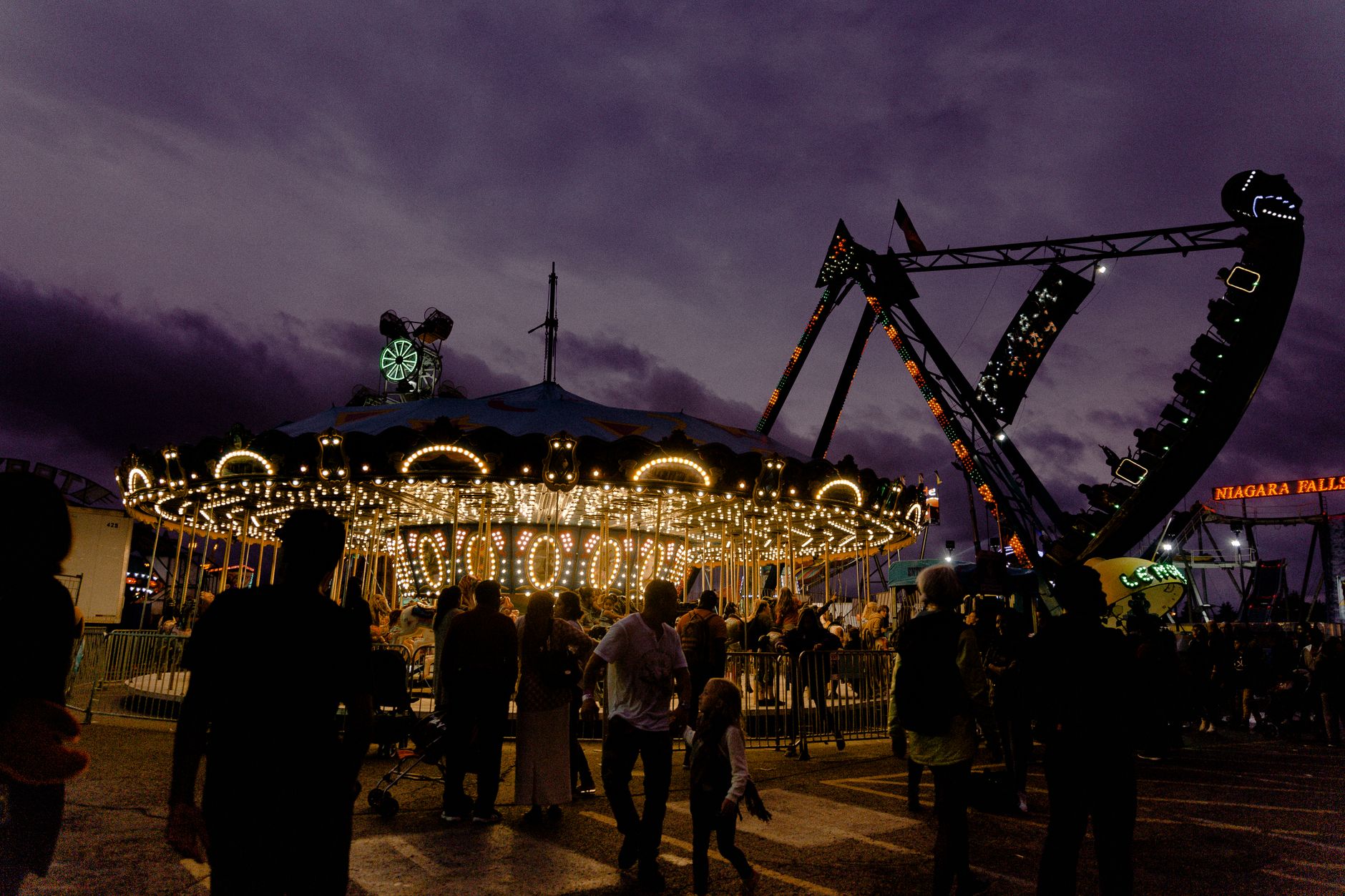 people enjoying rides at amusement park during sunset