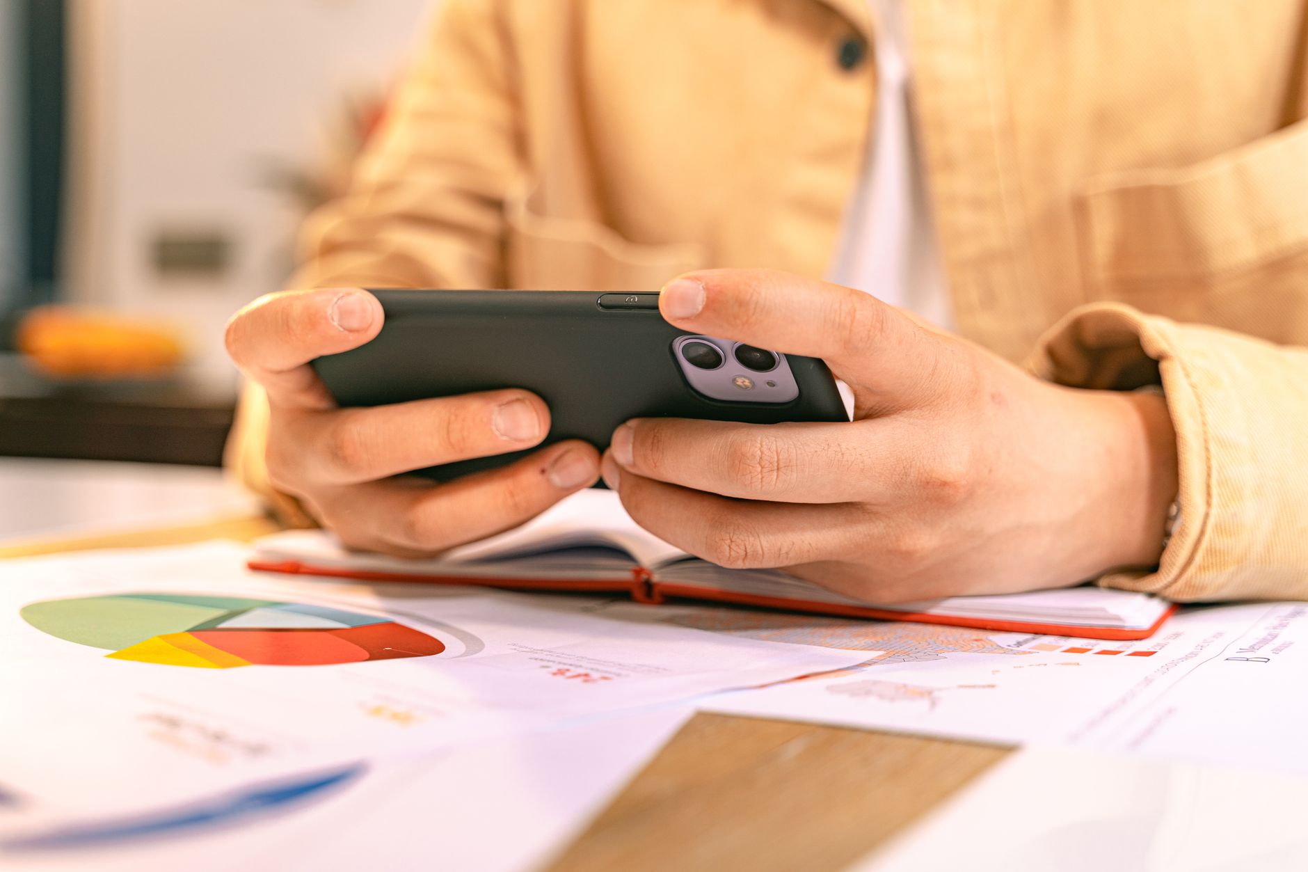 Woman checking smartphone at home office