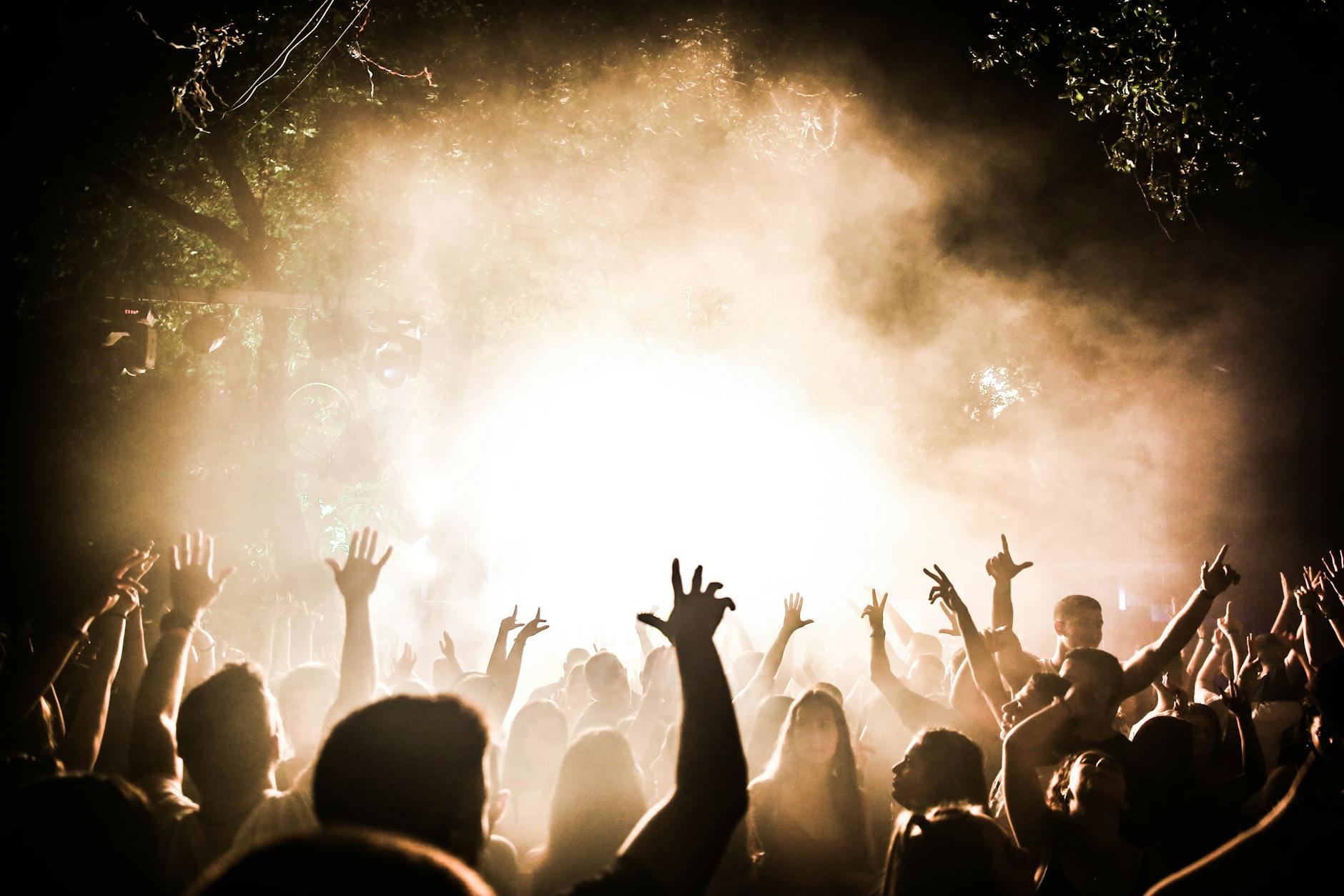 Concert crowd cheering at brightly lit stage