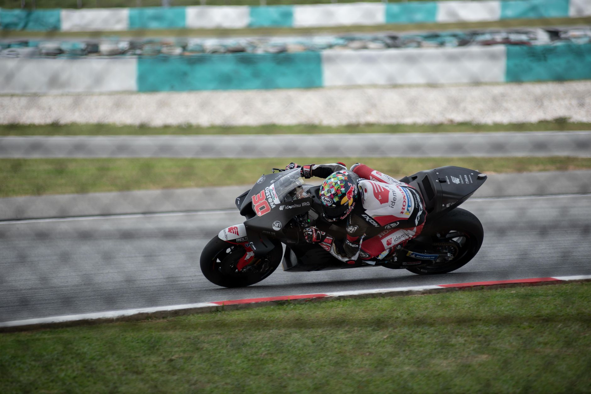 Moto3 racer leaning into turn on track