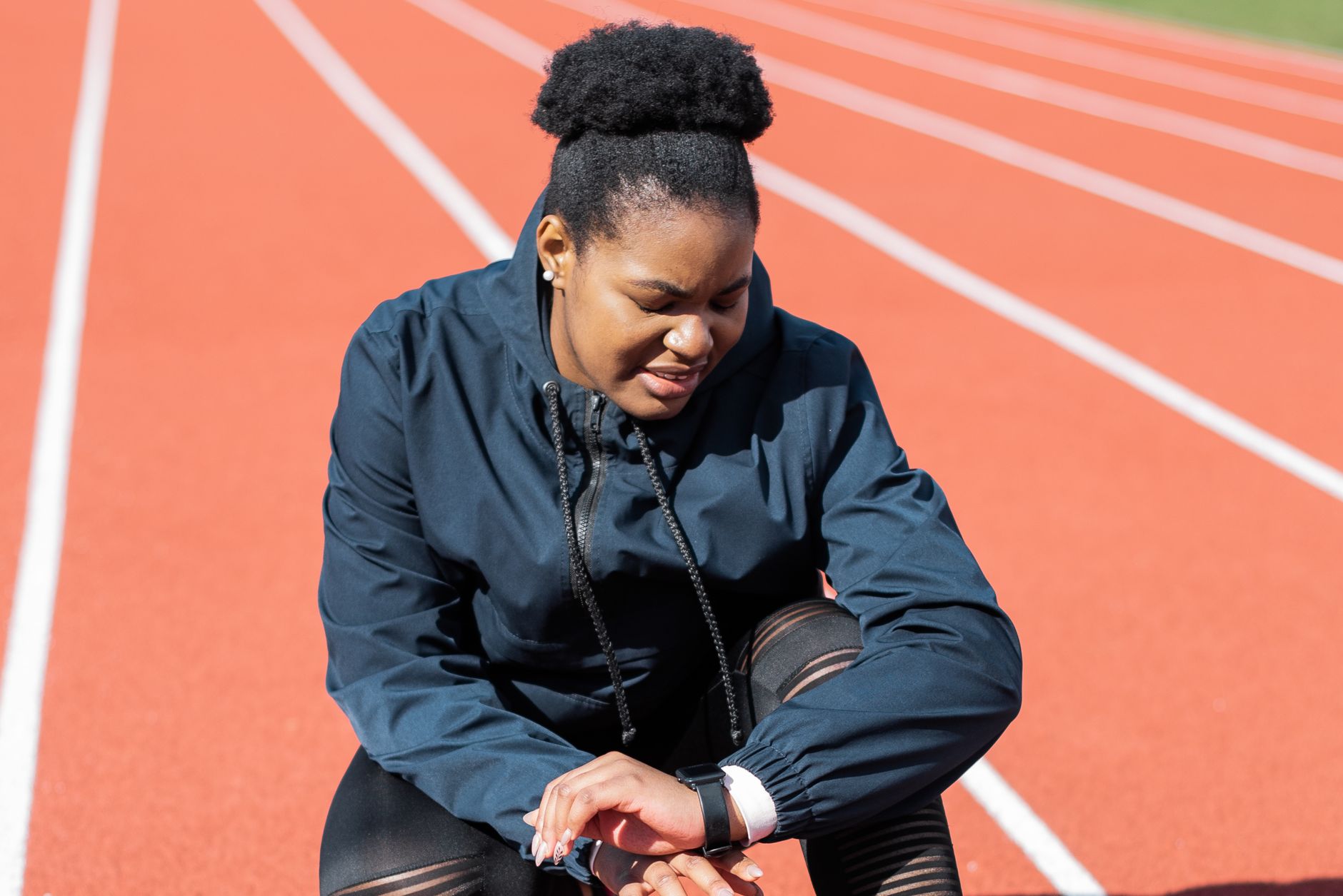Athlete checking fitness data on smartwatch during outdoor run
