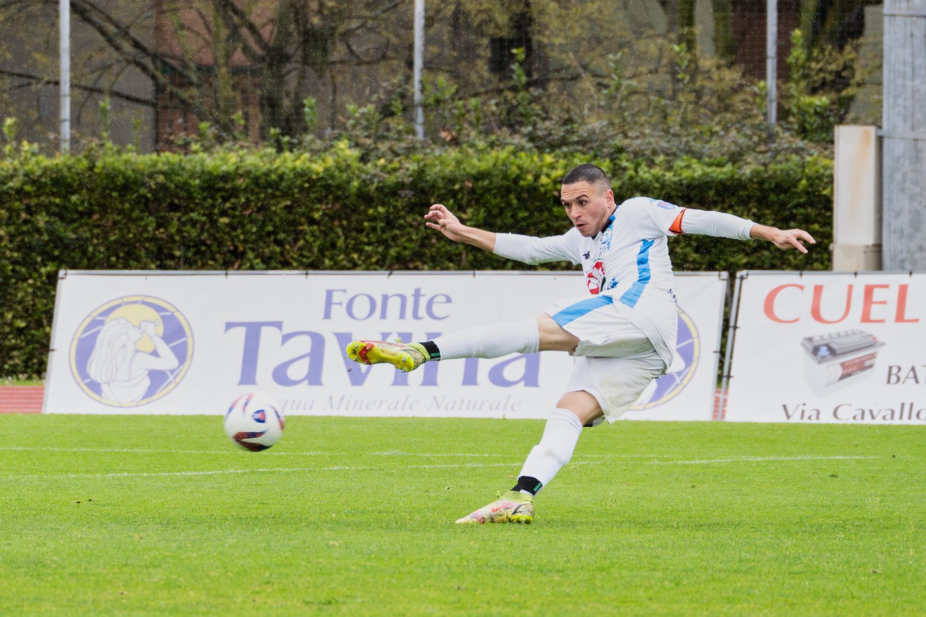 Hakan Çalhanoğlu kicking football on green field