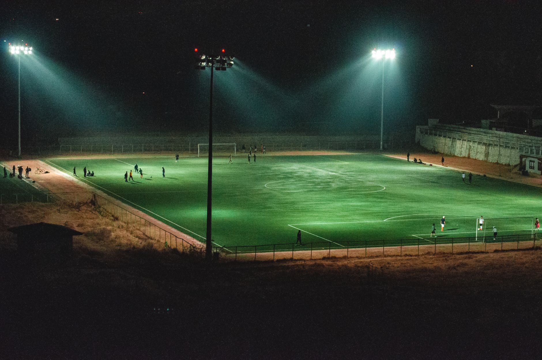 football players celebrating goal on field at night