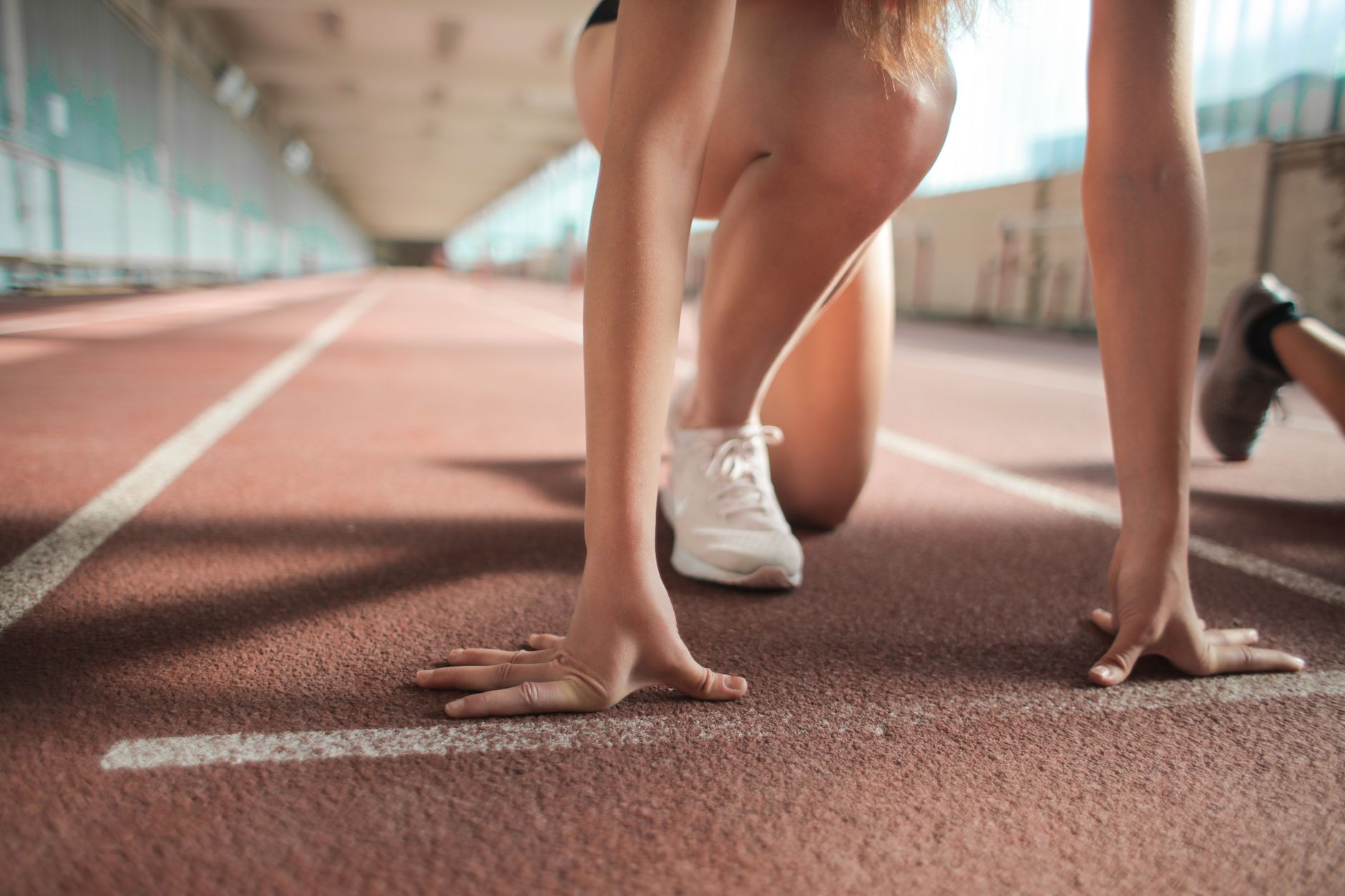 energetic female runner sprinting on track early morning