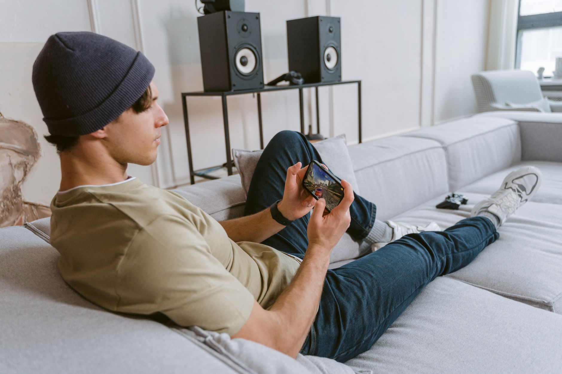 gamer hands holding smartphone playing mobile game in dark room
