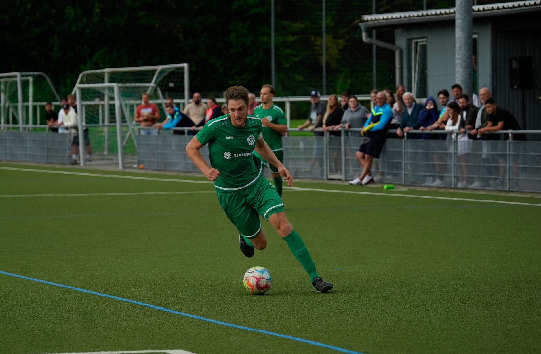 football player dribbling ball on green field