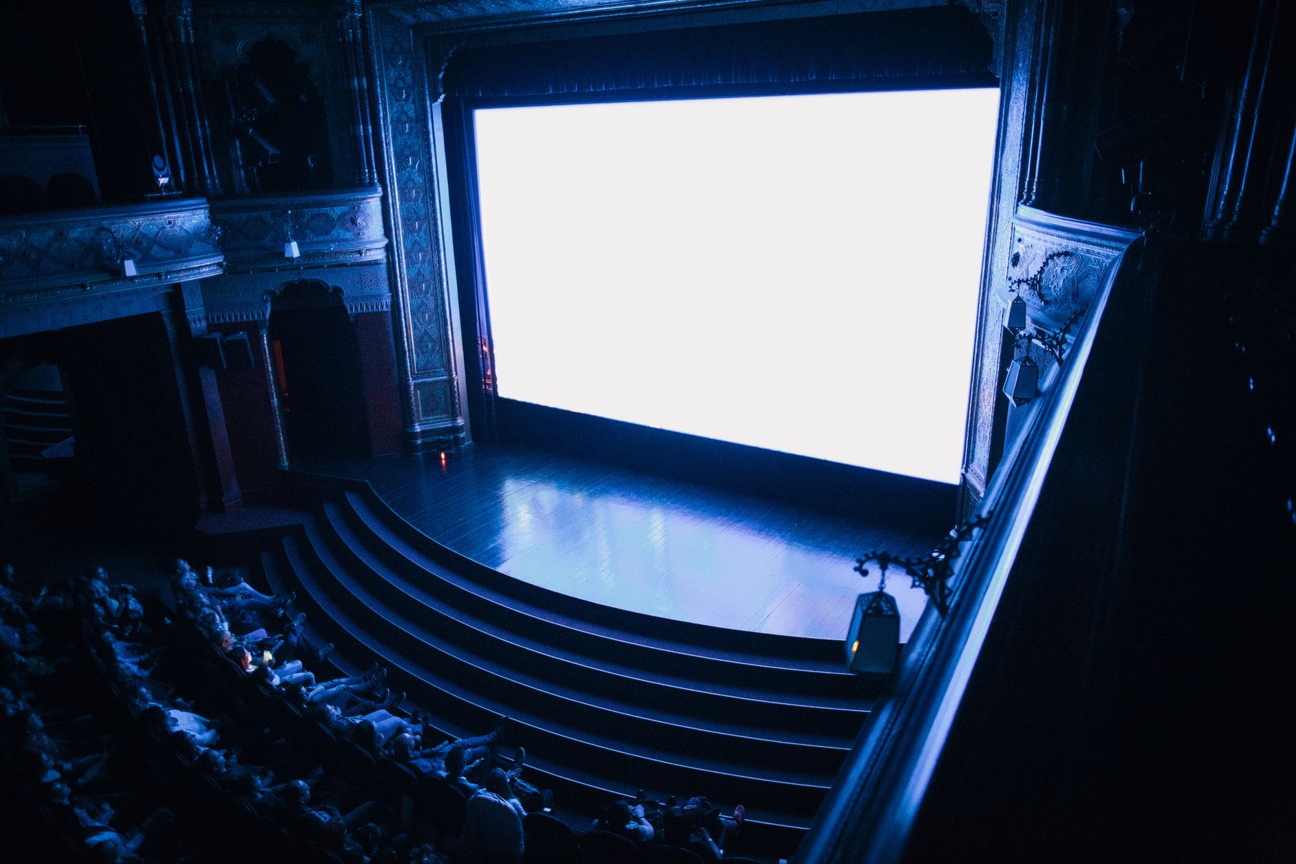 audience watching movie in dark cinema hall