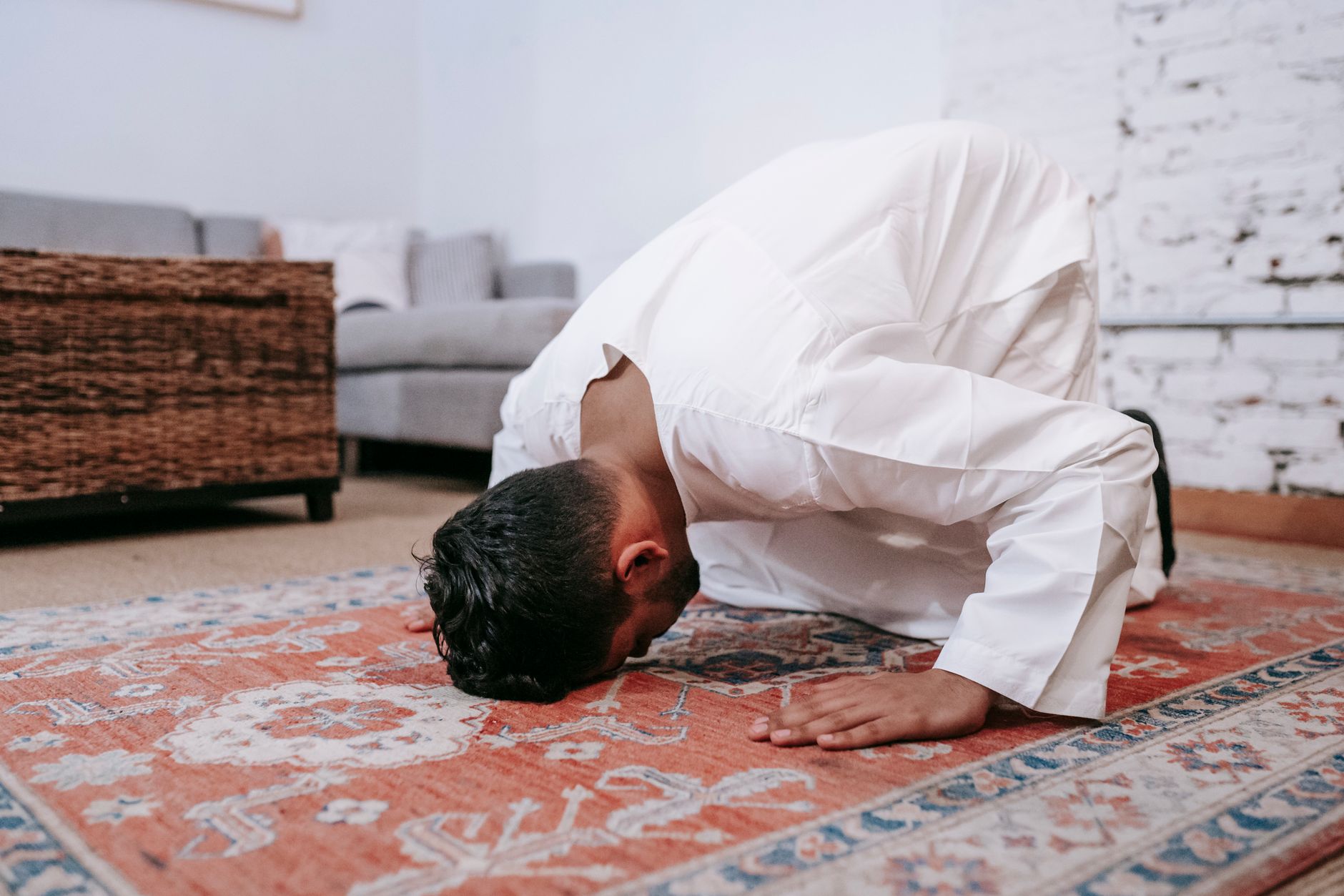 muslim man performing prayer rug home