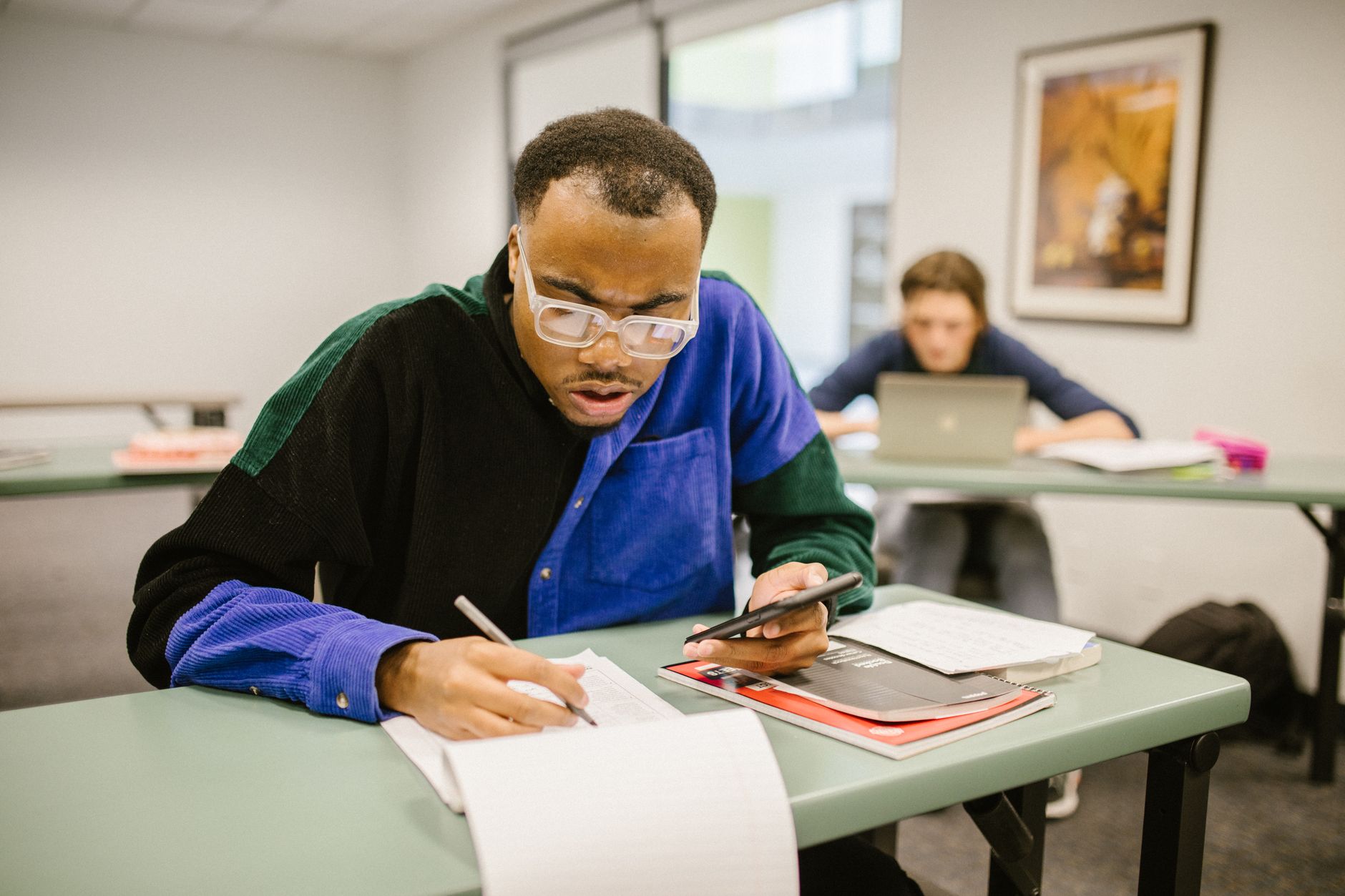 student writing exam in classroom with focus