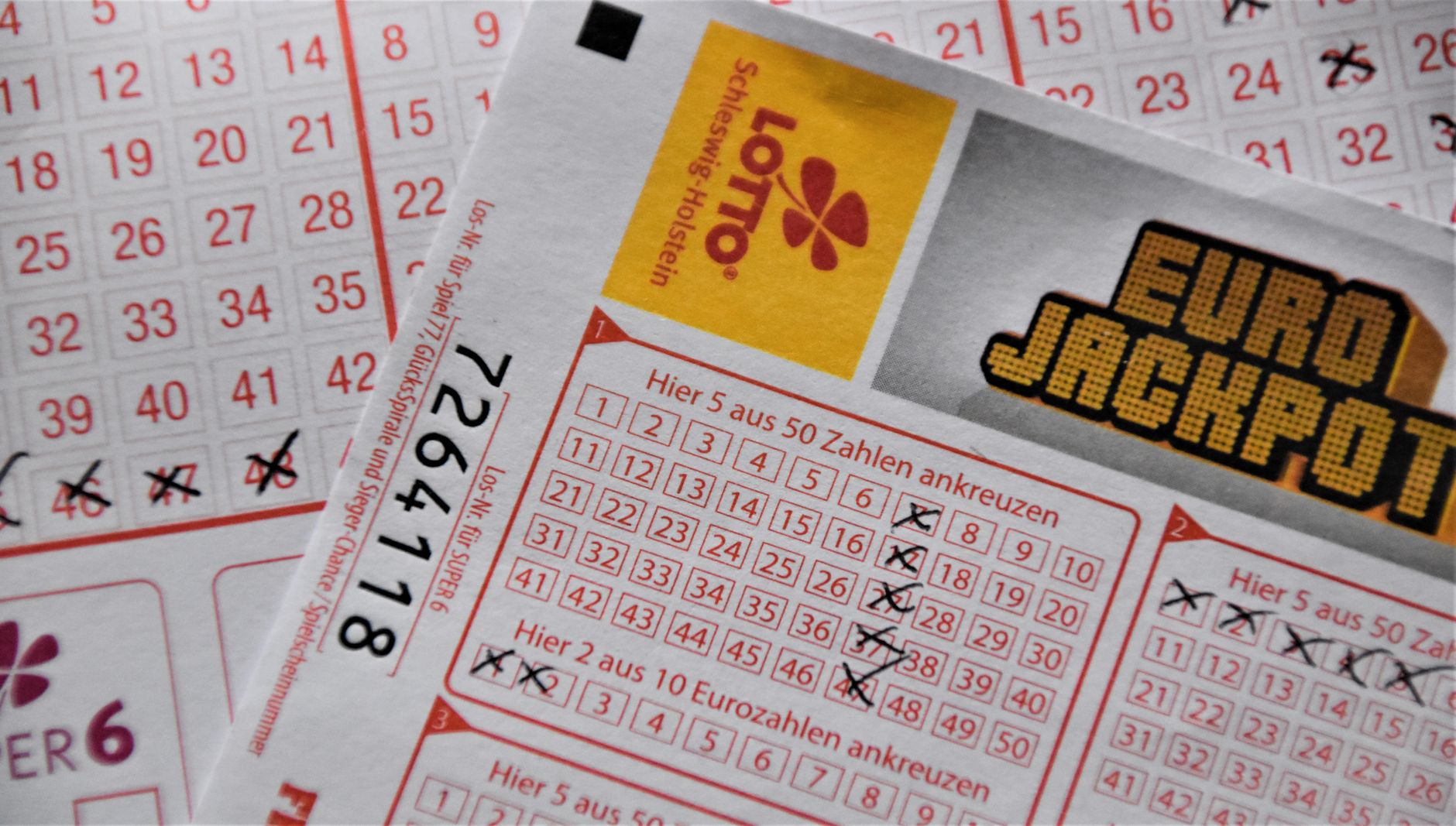hand holding lottery ticket comparing numbers to screen