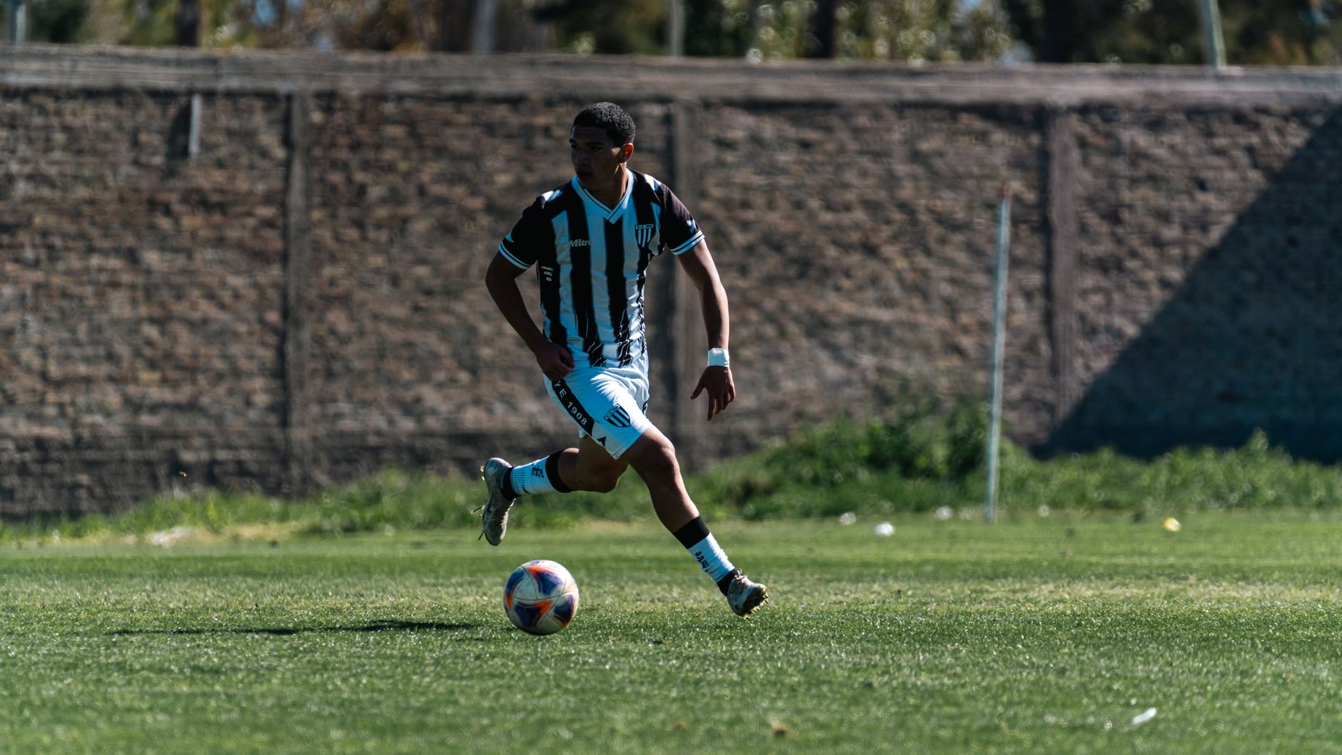 football player dribbling ball during match