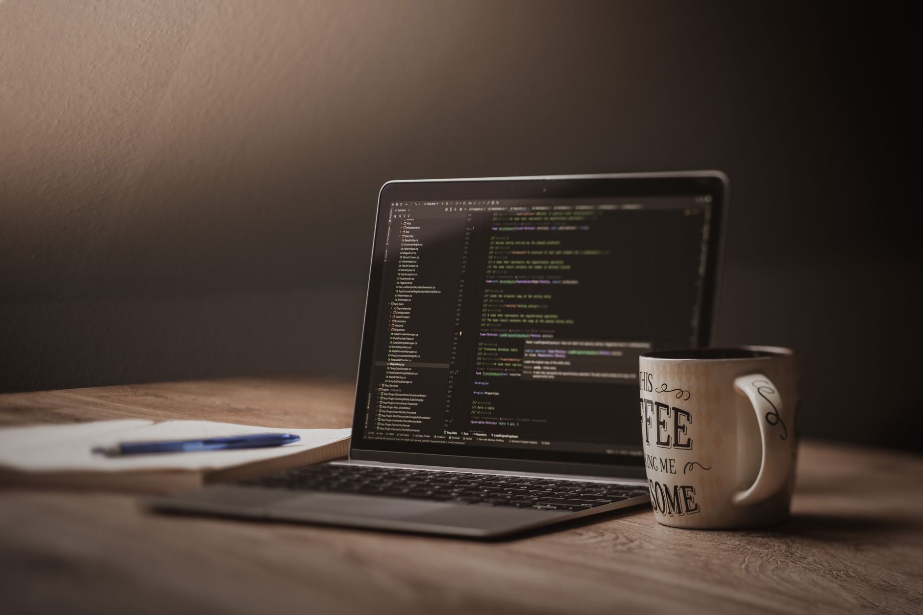 open laptop on wooden desk with coffee mug
