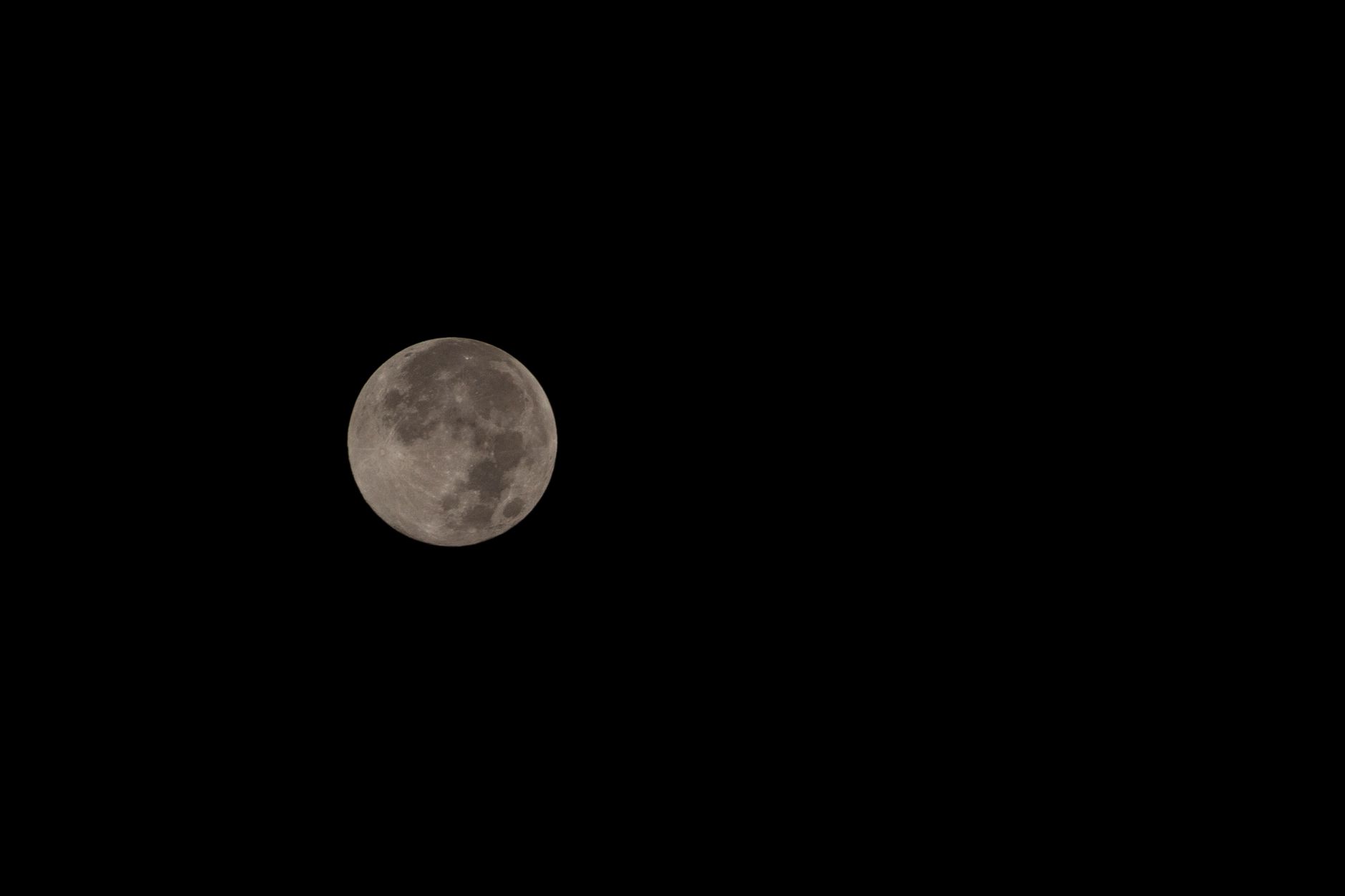 person observing night sky full moon through telescope
