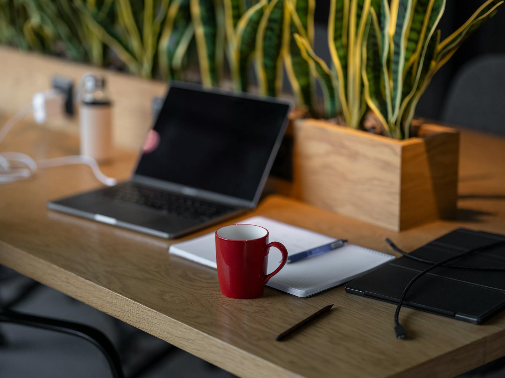 open laptop on wooden desk with coffee mug
