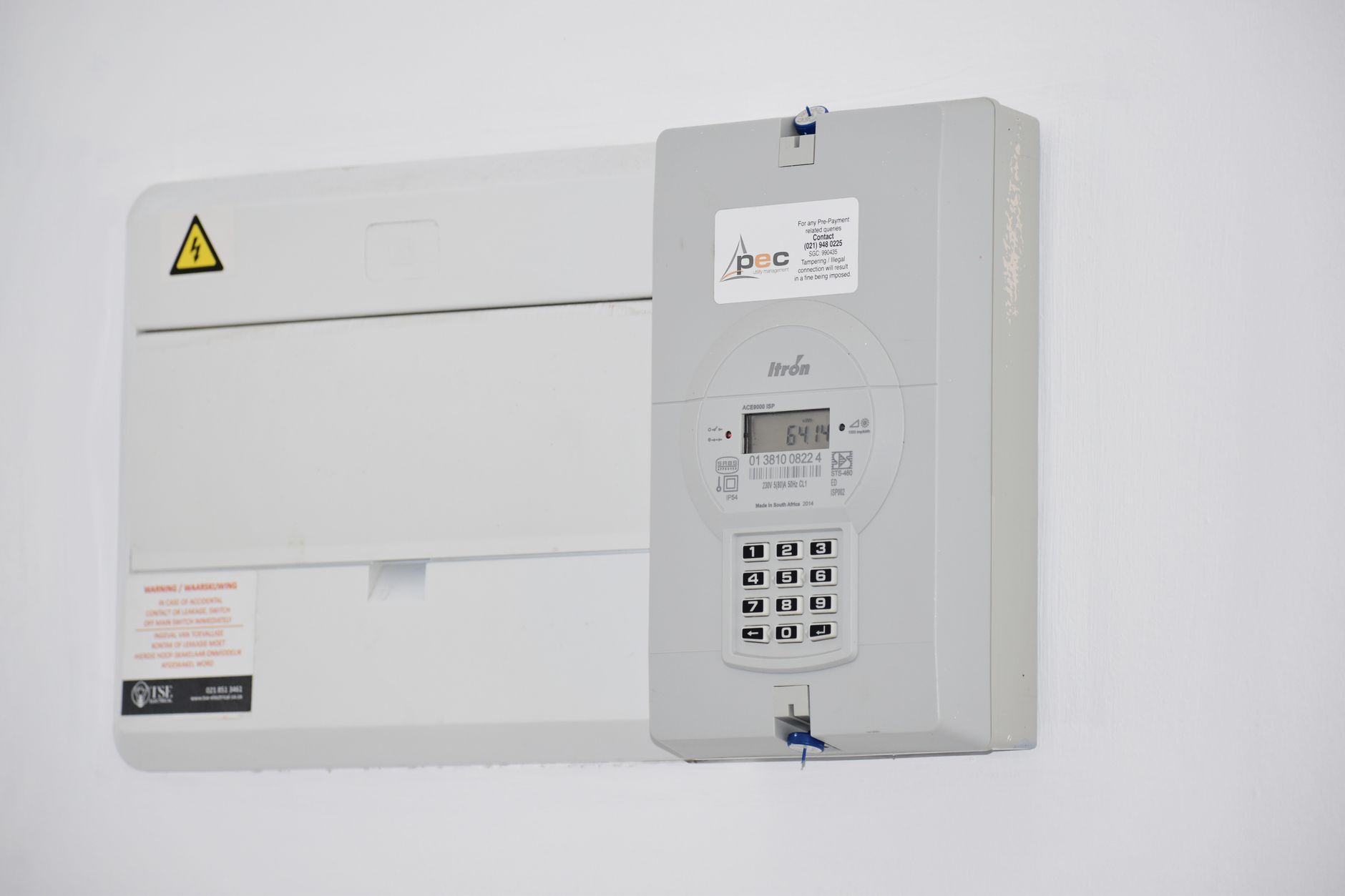 close-up of hand entering 20-digit code on digital electricity meter
