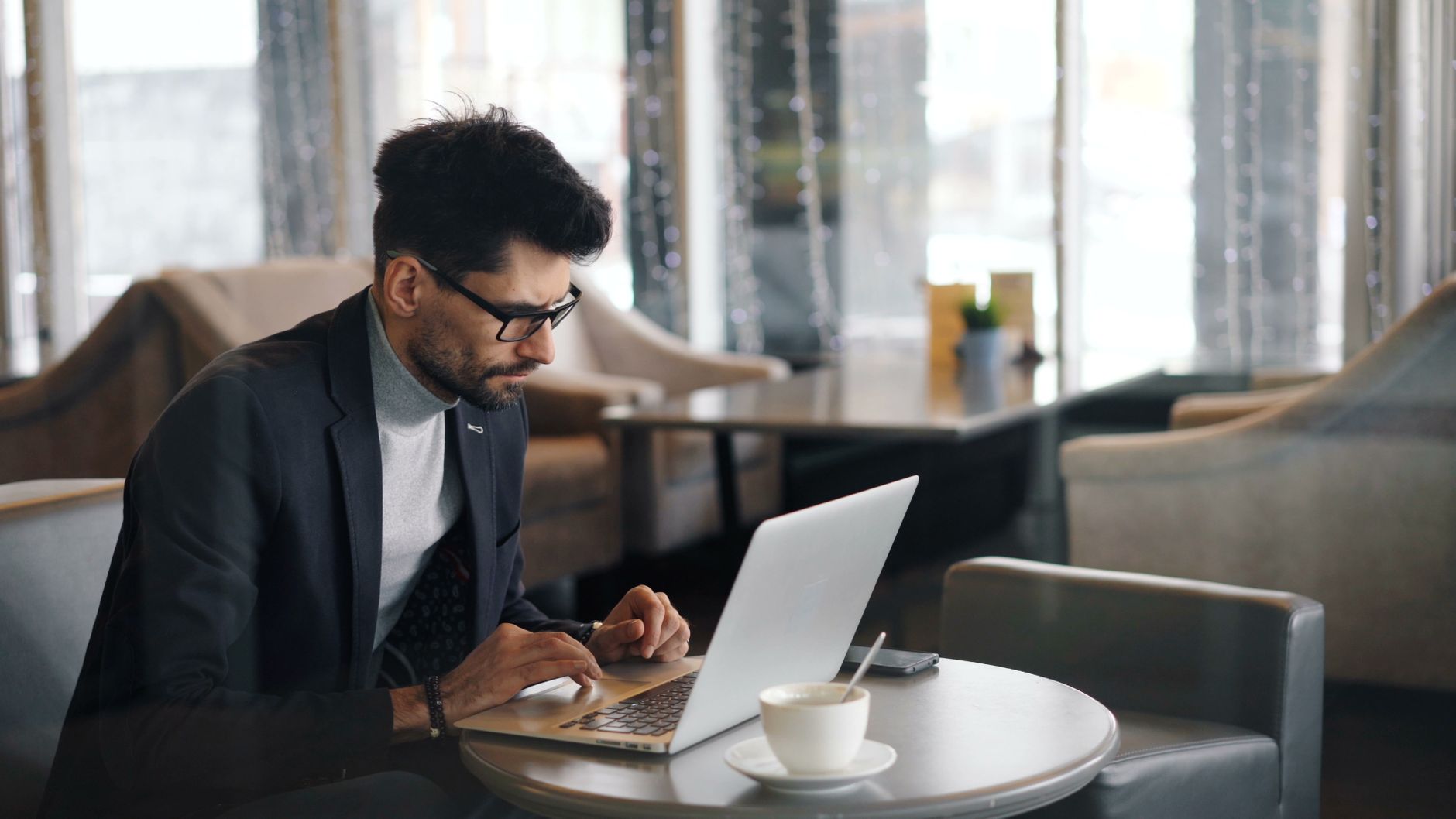 journalist typing article laptop coffee shop