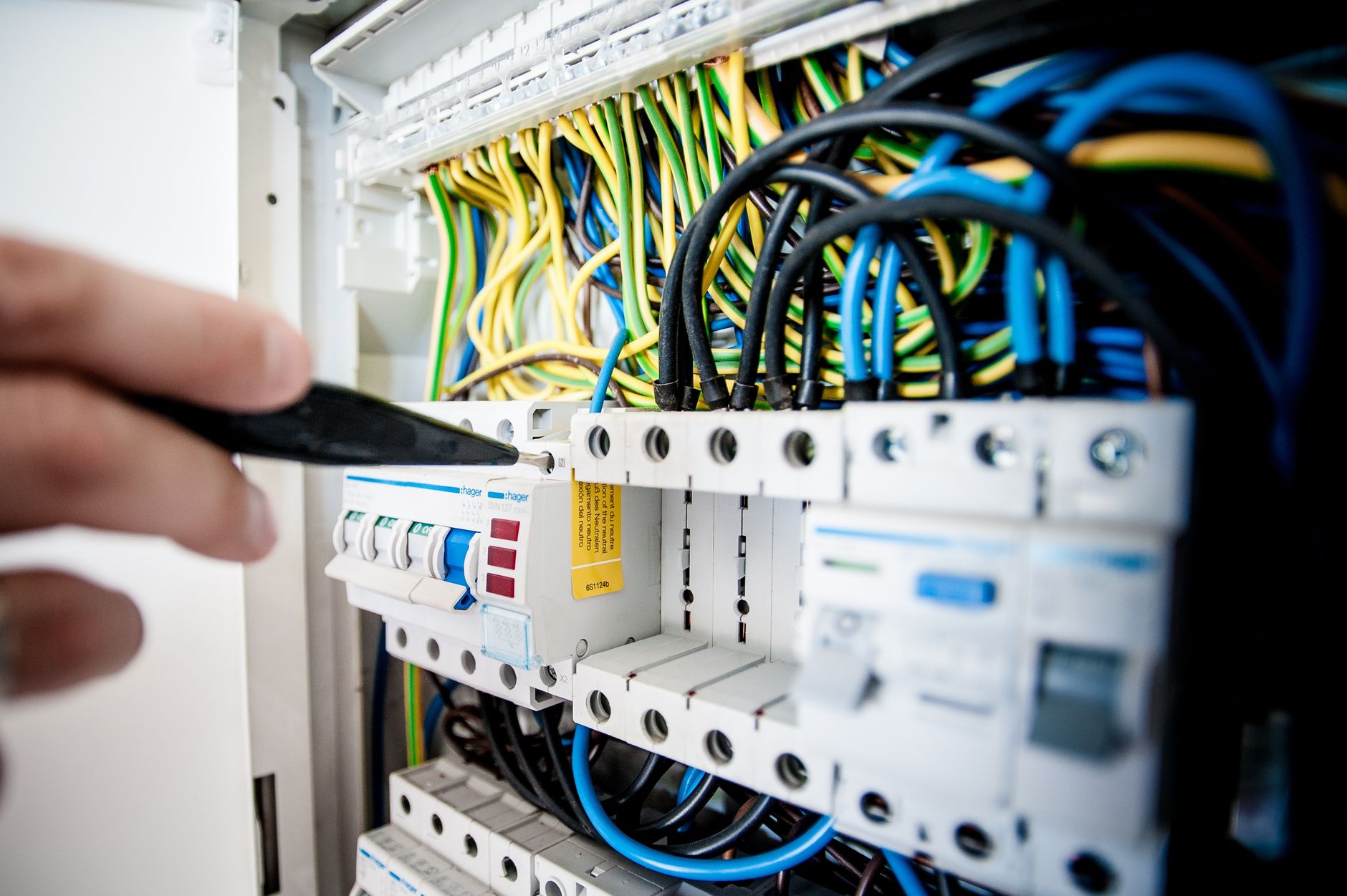 electrician hands checking fuse box wires