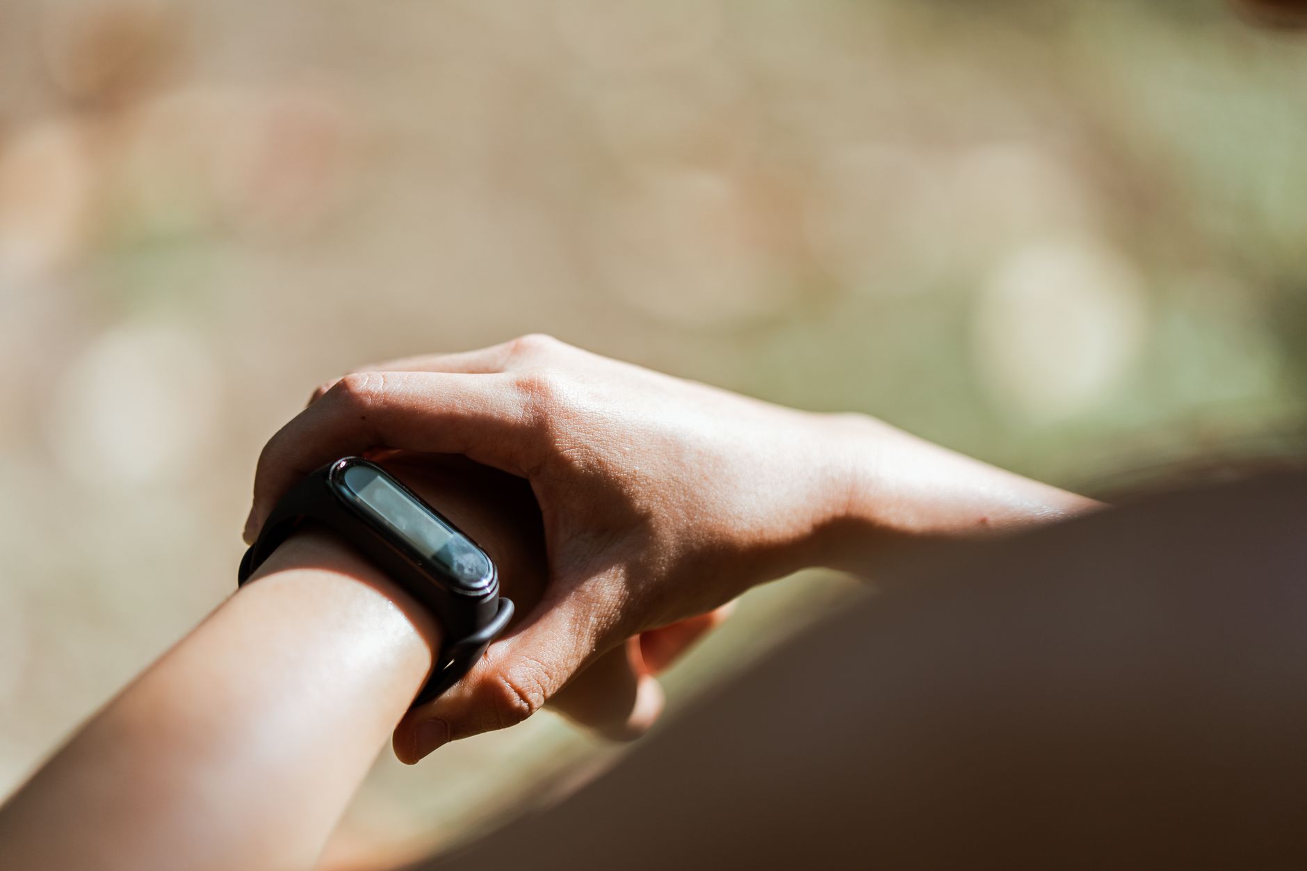 runner checking smartwatch on wrist during morning run