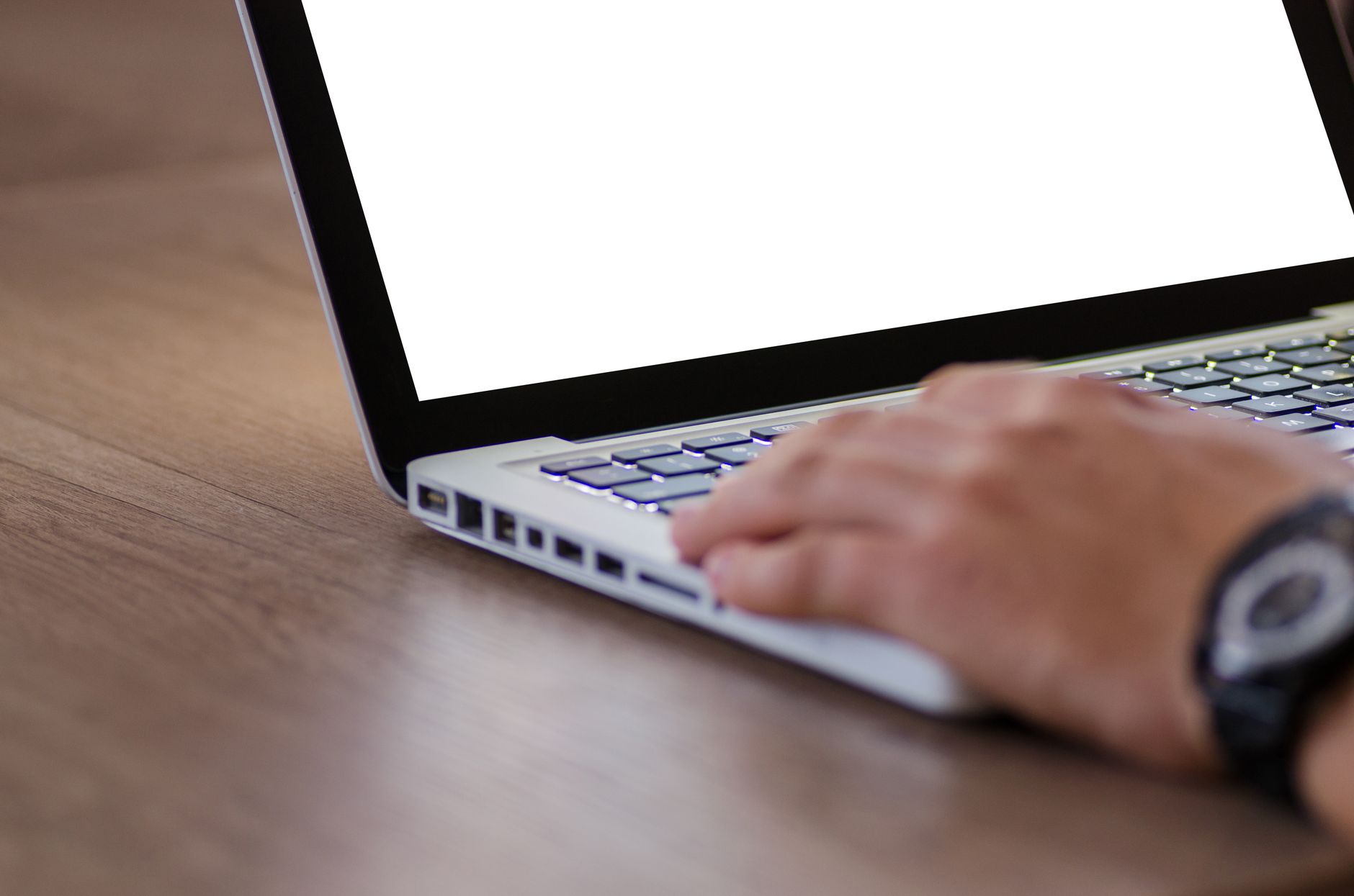 person typing on laptop keyboard in office