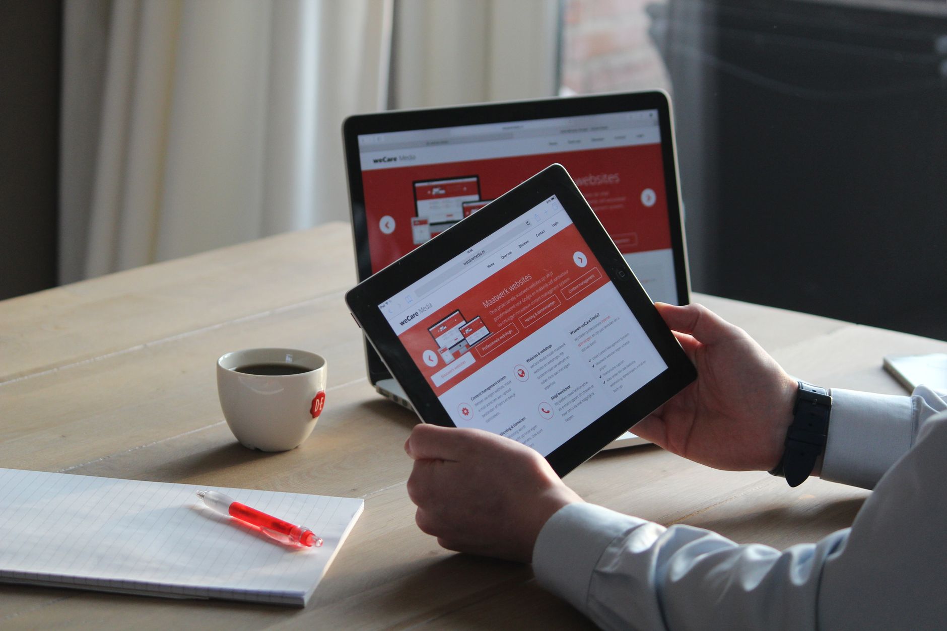 hands holding tablet browsing website