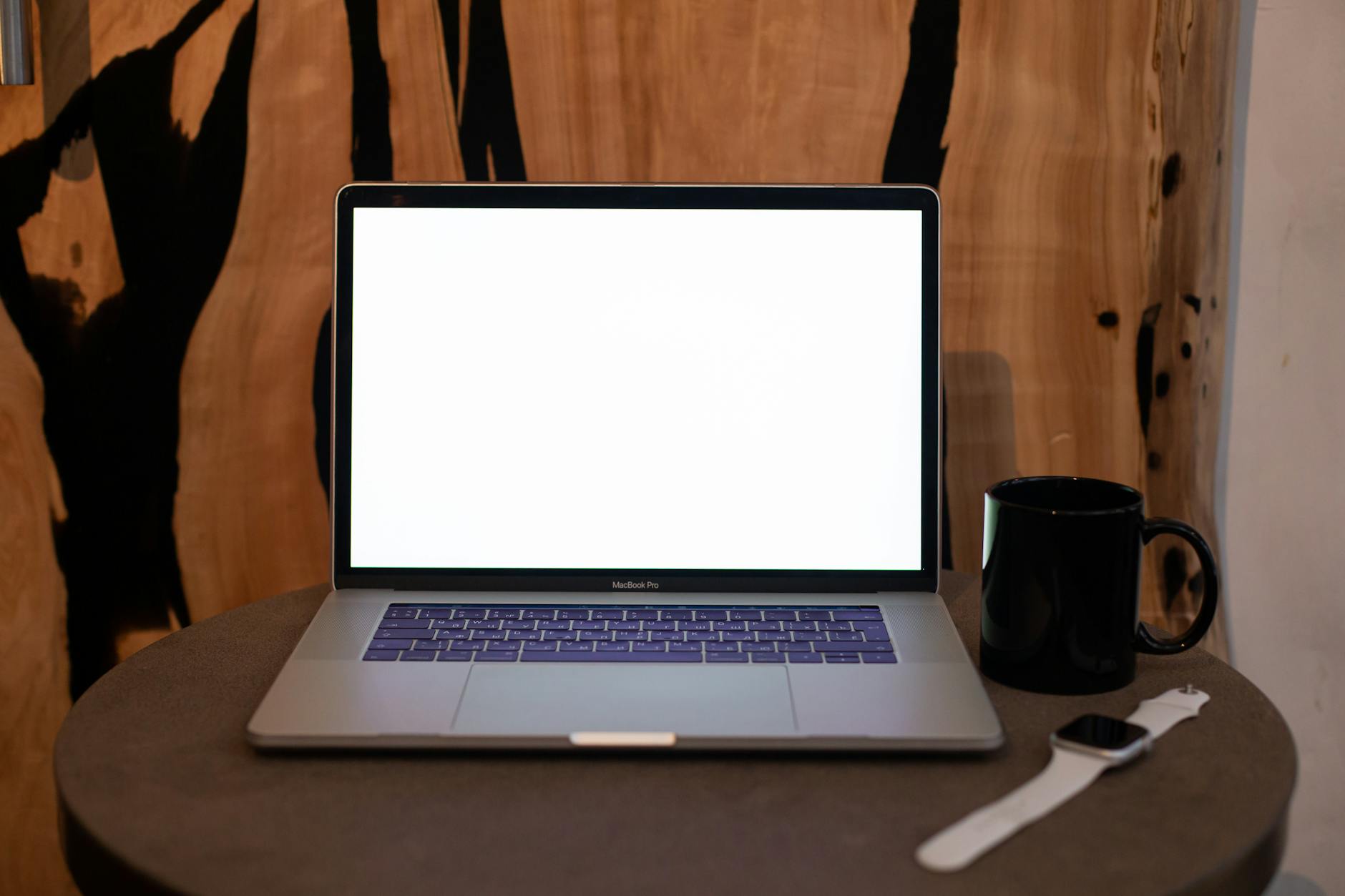 open laptop on wooden desk with coffee mug