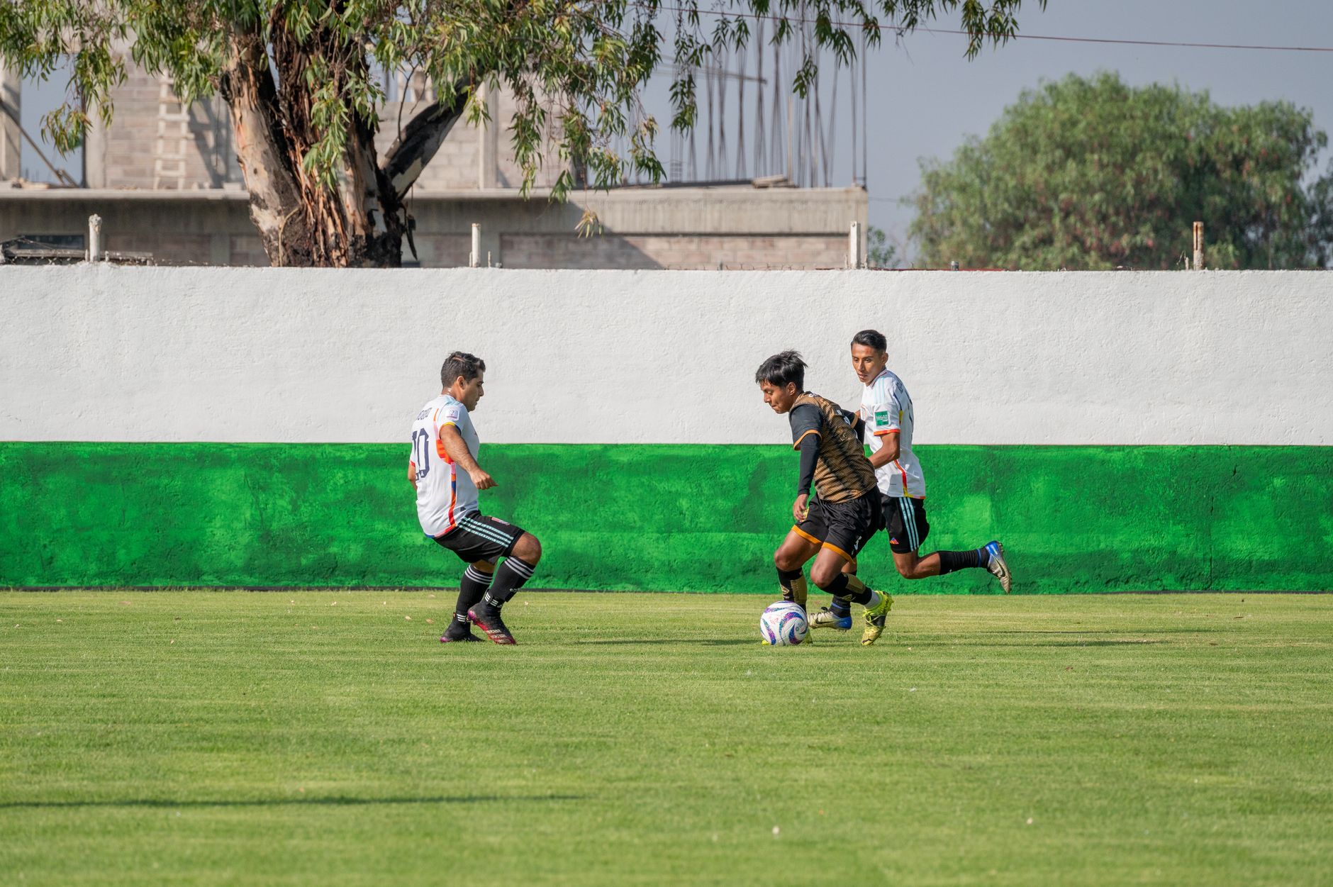 football players competing for ball on green field