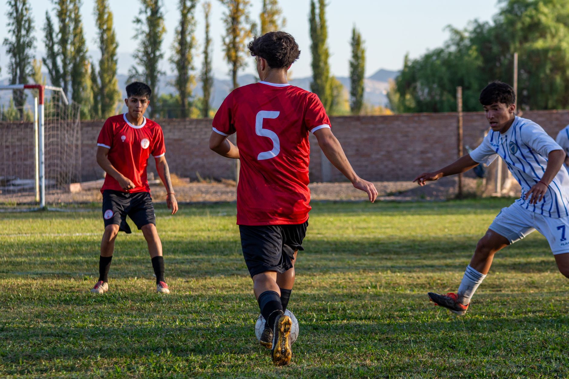 indonesian and oman football players competing for ball on green field