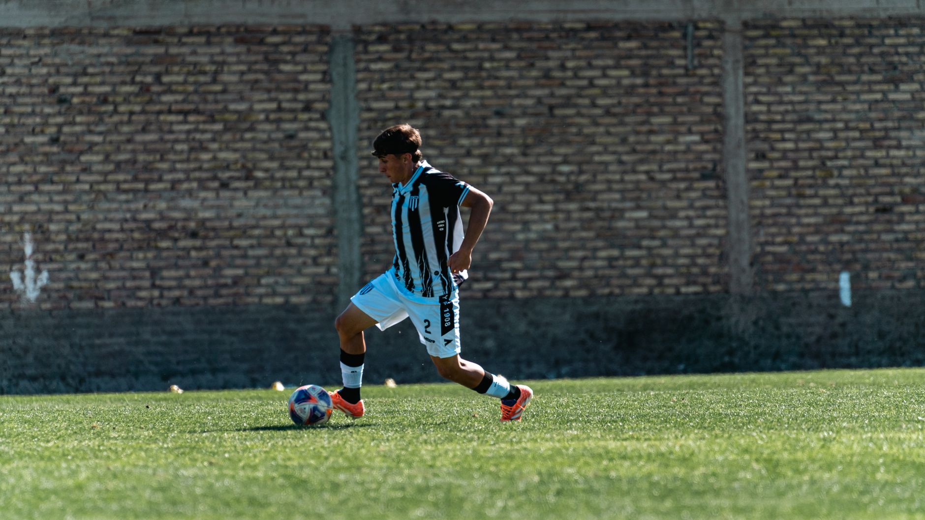 young football player in Juventus jersey dribbling ball