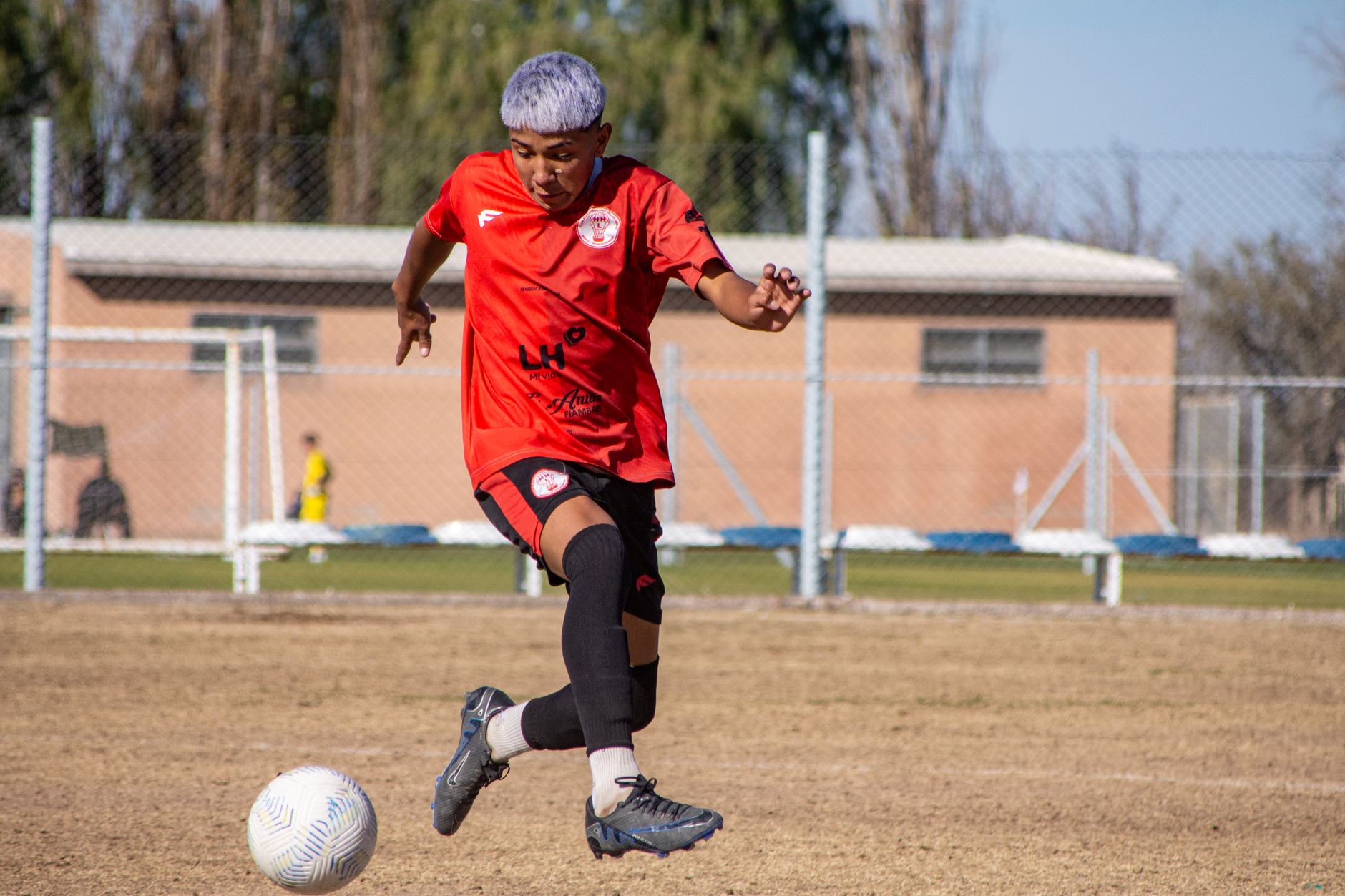winger dribbling ball on field during soccer match