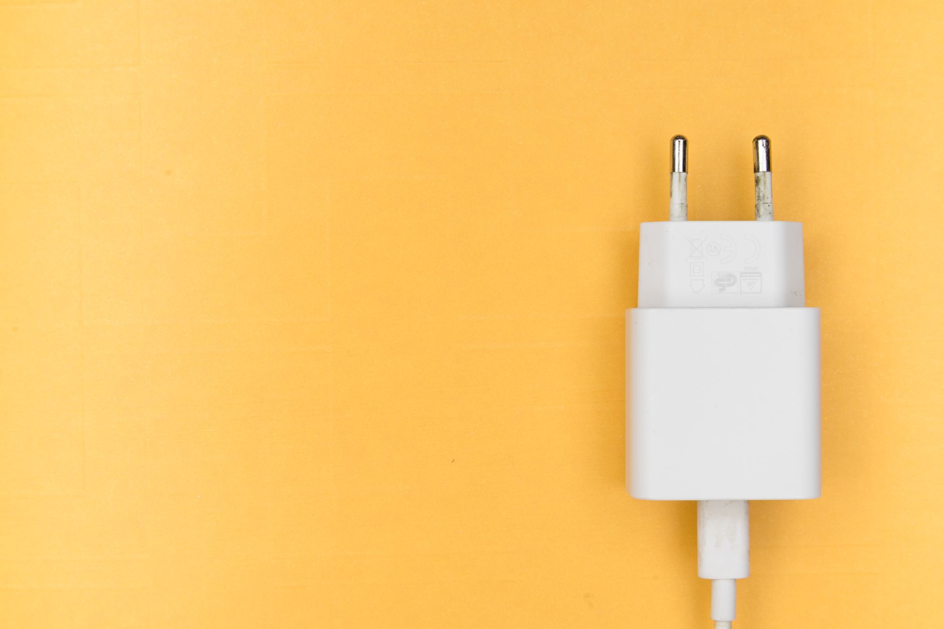 person plugging phone charger into wall