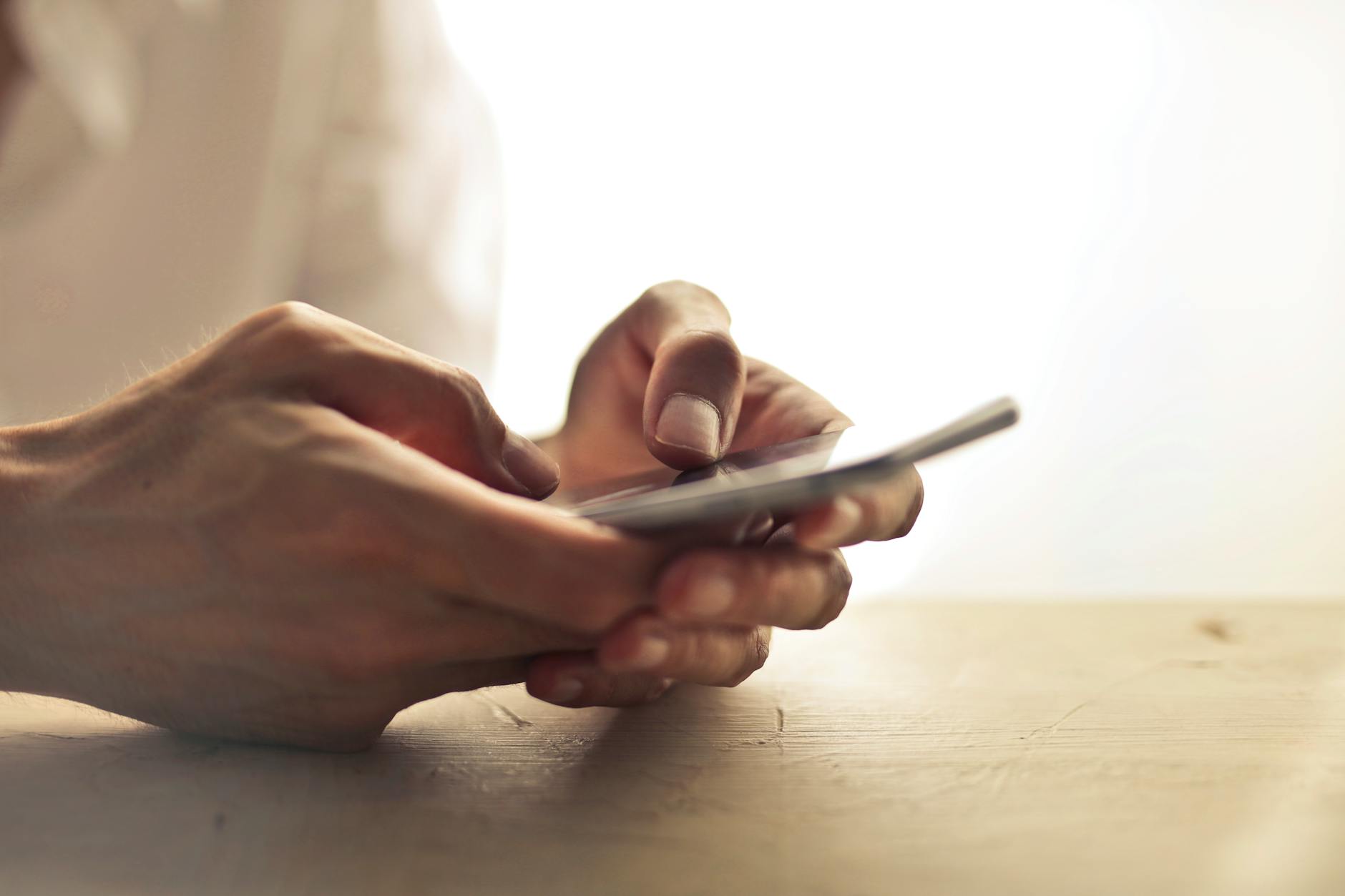 hand holding smartphone browsing apps bright screen