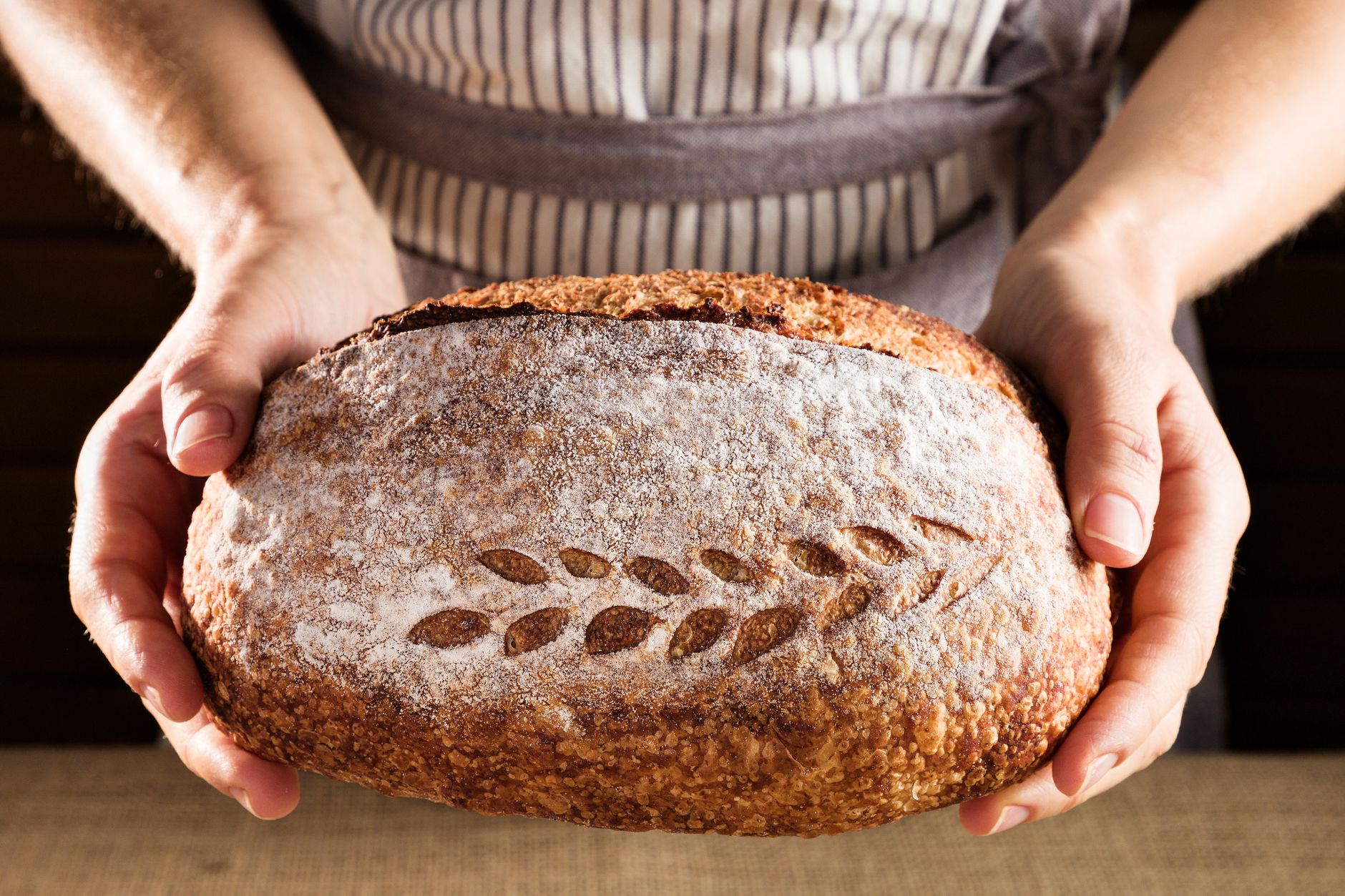 woman holding whole grain bread in grocery aisle