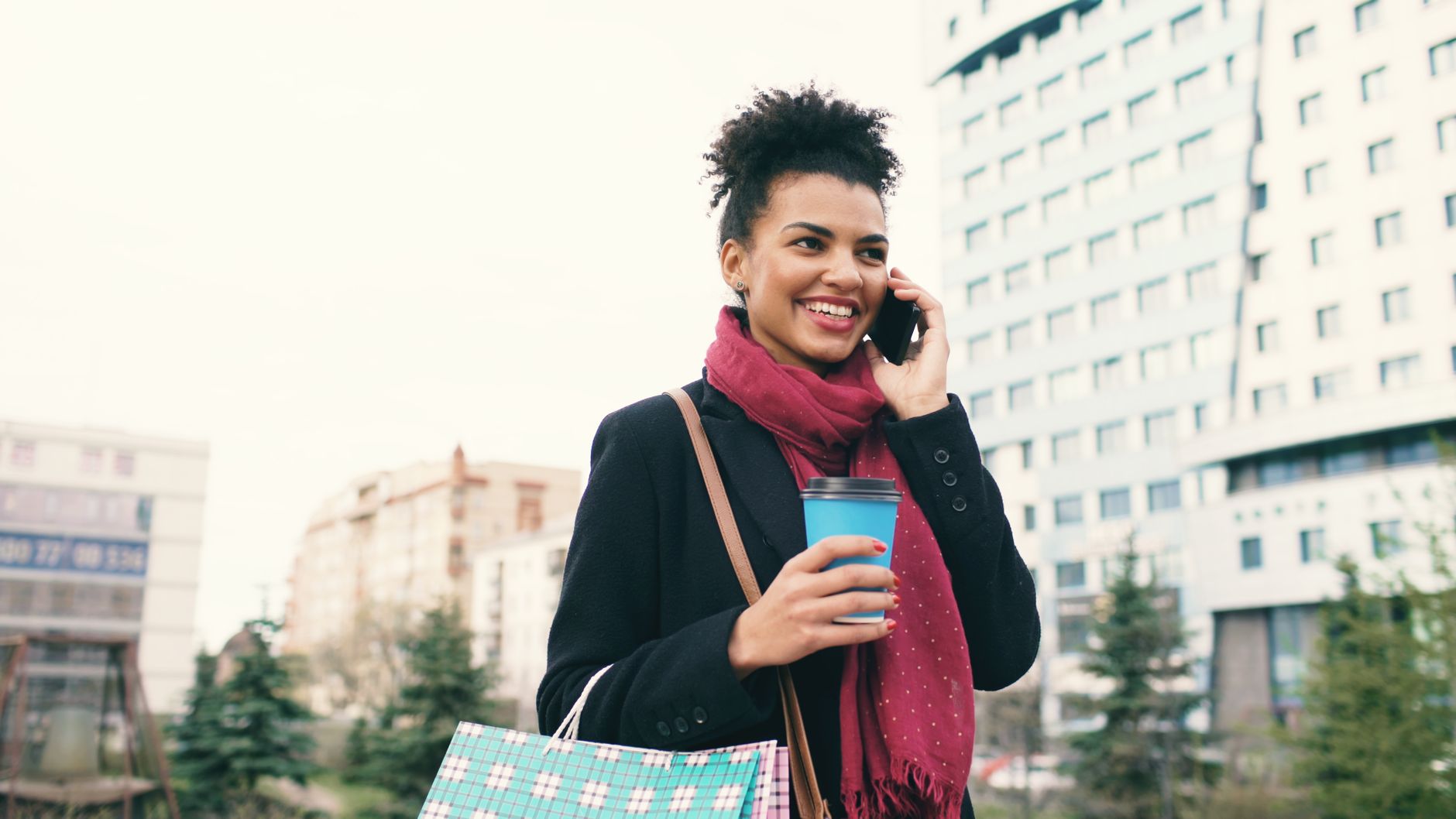Woman holding smartphone in coffee shop