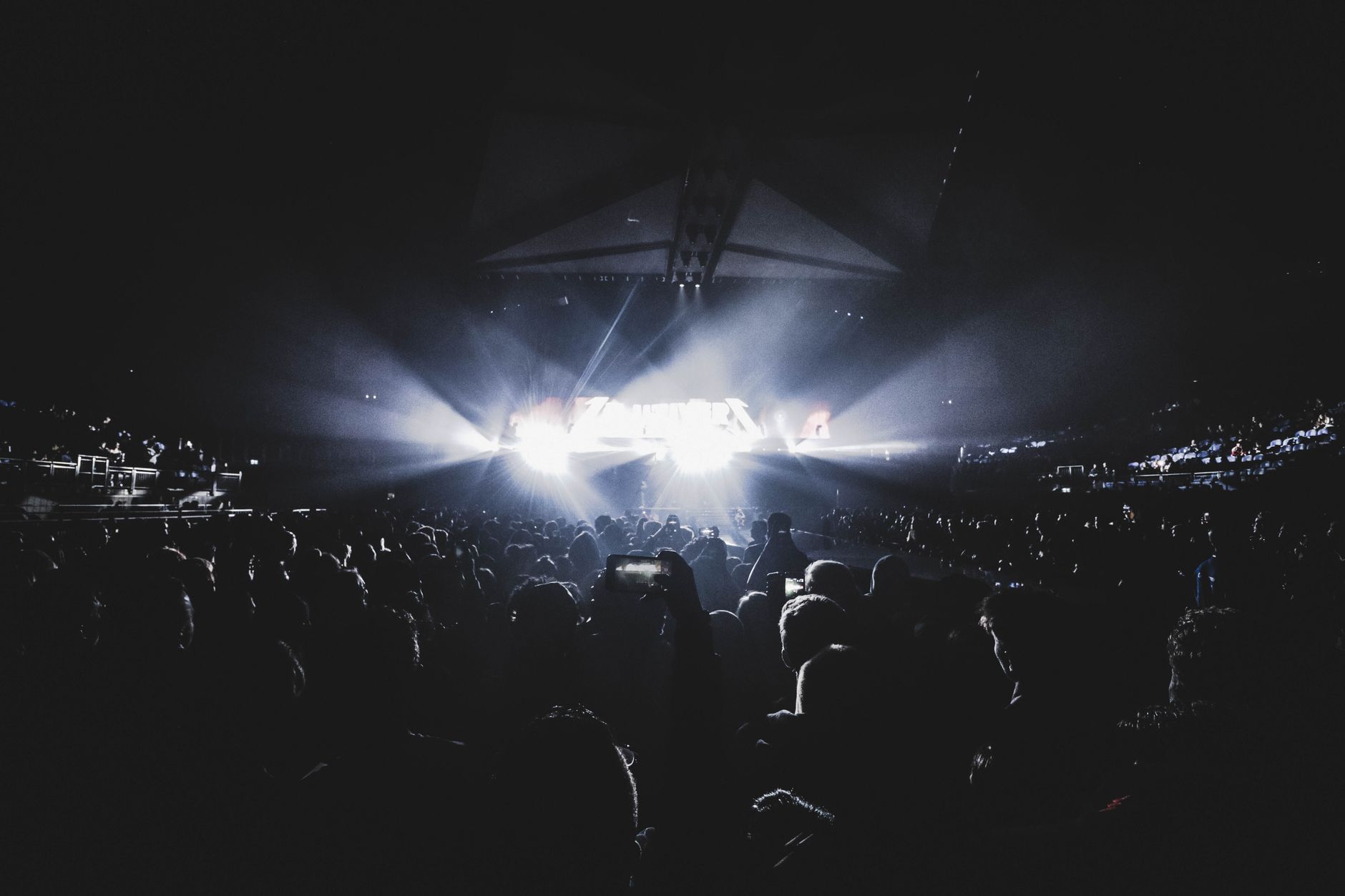audience watching concert stage with bright lights