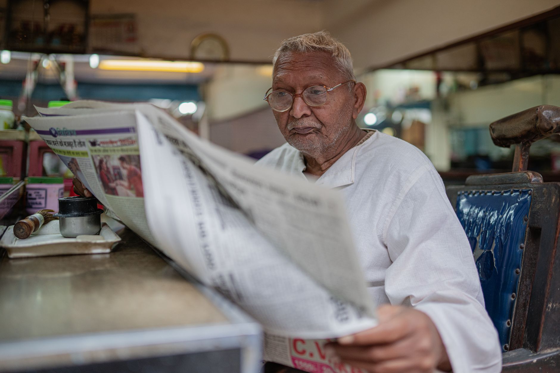 person reading international newspaper at cafe table
