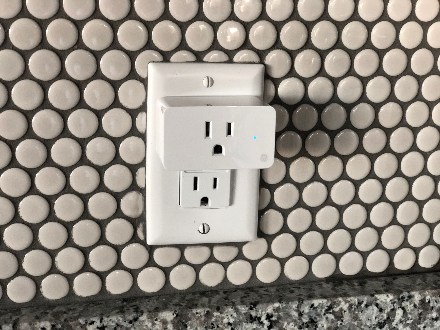 hand plugging in power cord to wall outlet