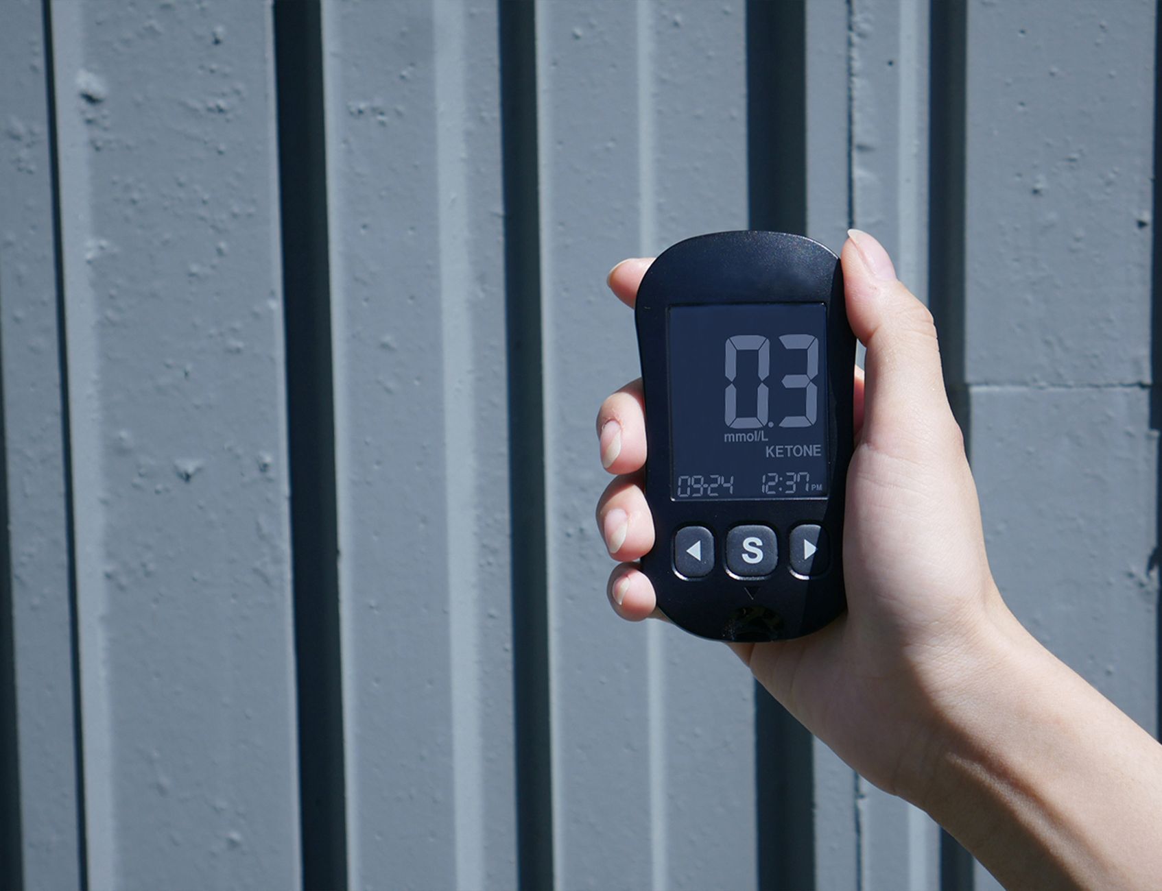 close-up of digital electricity meter display with hand entering numbers